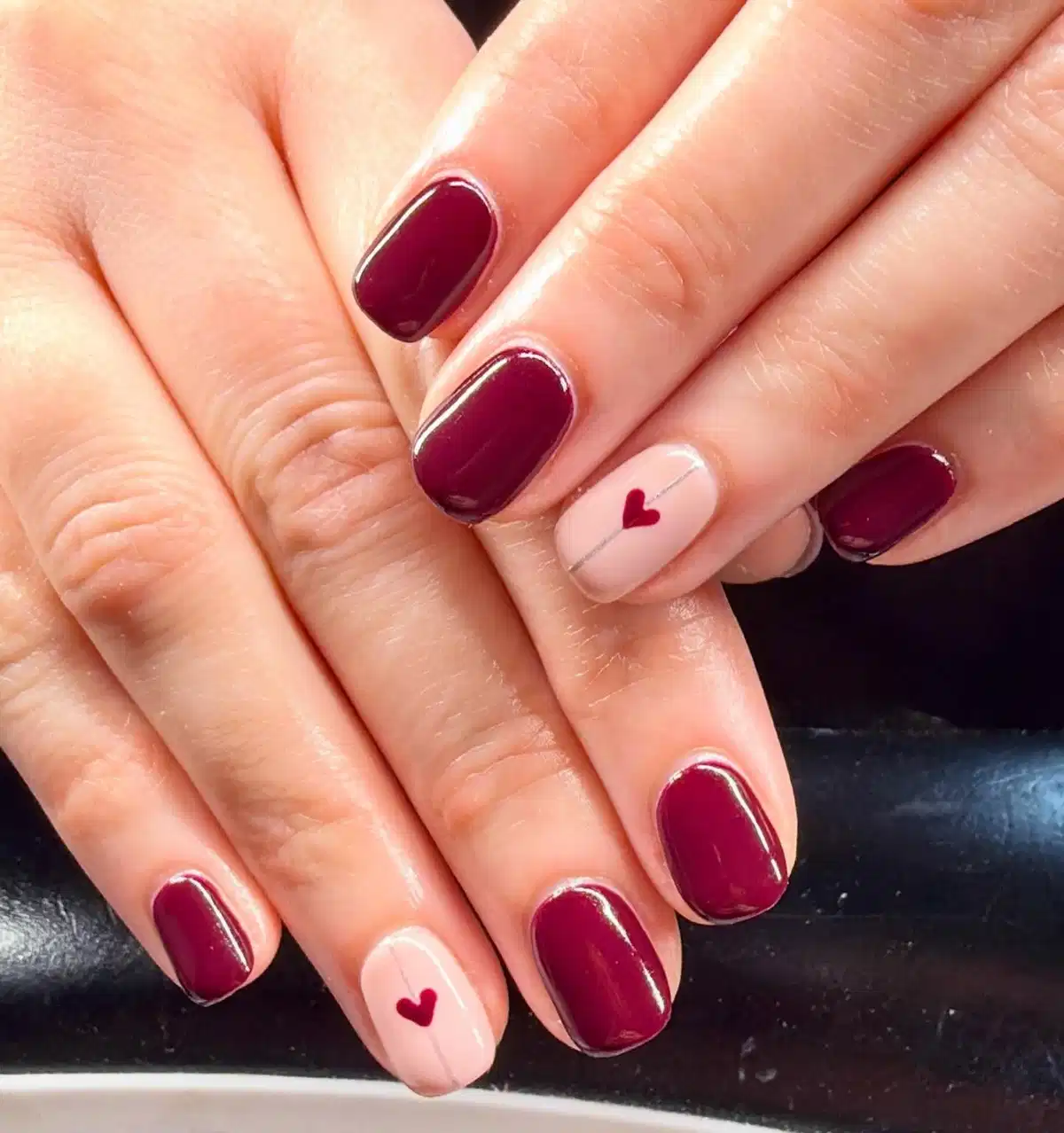 Short maroon nails with nude heart accent nails