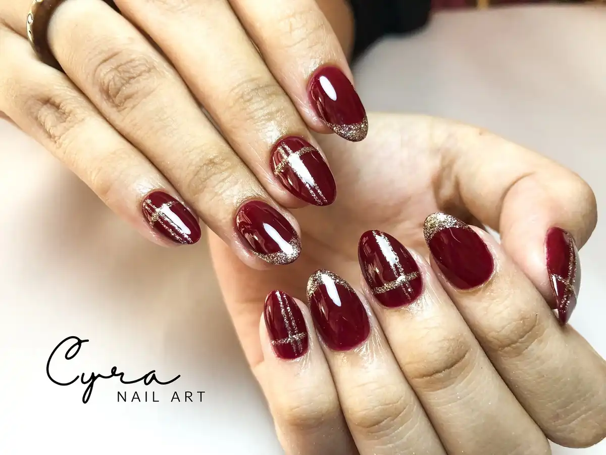Maroon Nails with Fine Gold Glitter Striping