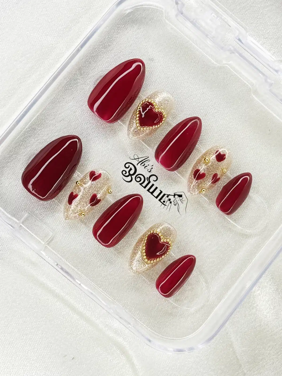 Glossy maroon set with glitter-heart accents and gold beads