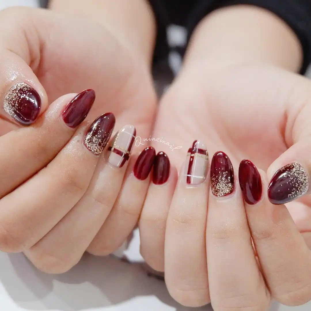 Maroon almond nails with grid accent nails and glitter tips