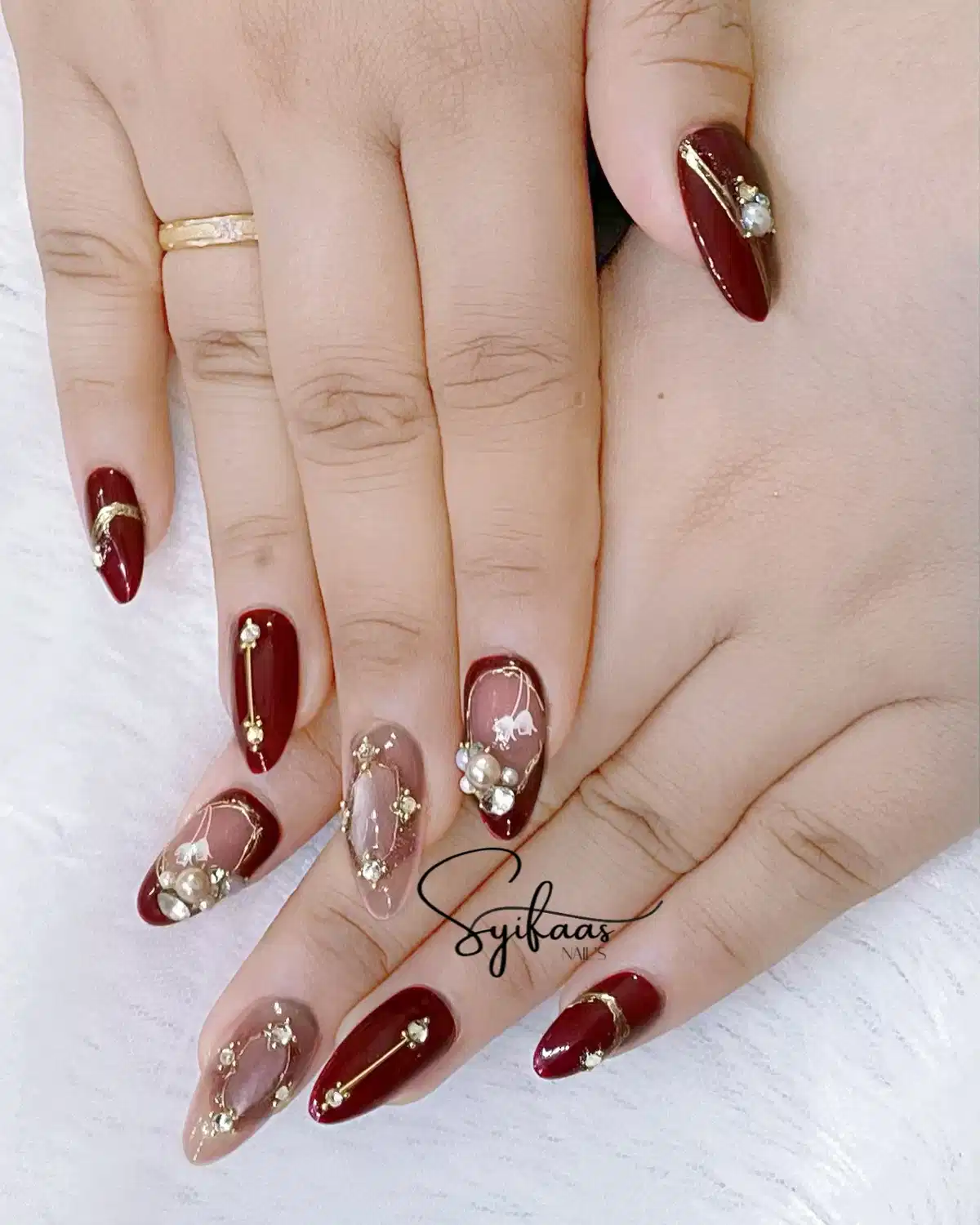 Maroon and nude mix with gold bars, pearl-like clusters, and ornate outlines