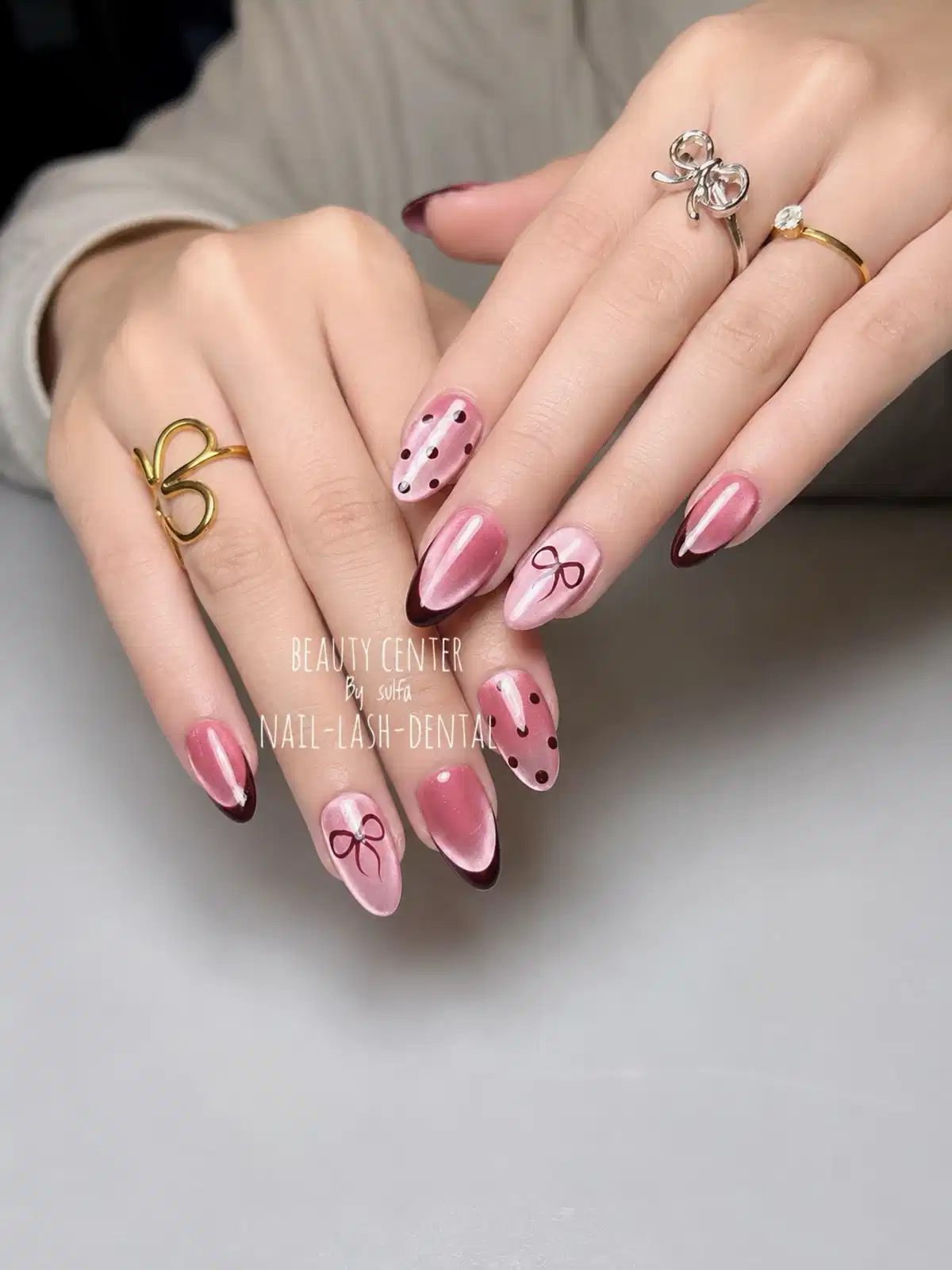 Pink-and-maroon French tips with polka dots and bow art