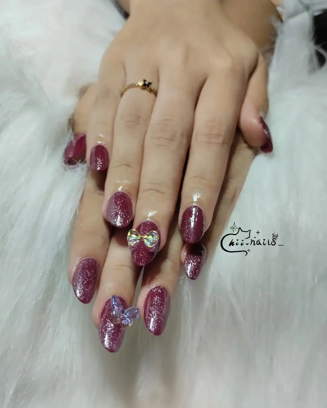 Maroon glitter nails with 3D bow and butterfly accents