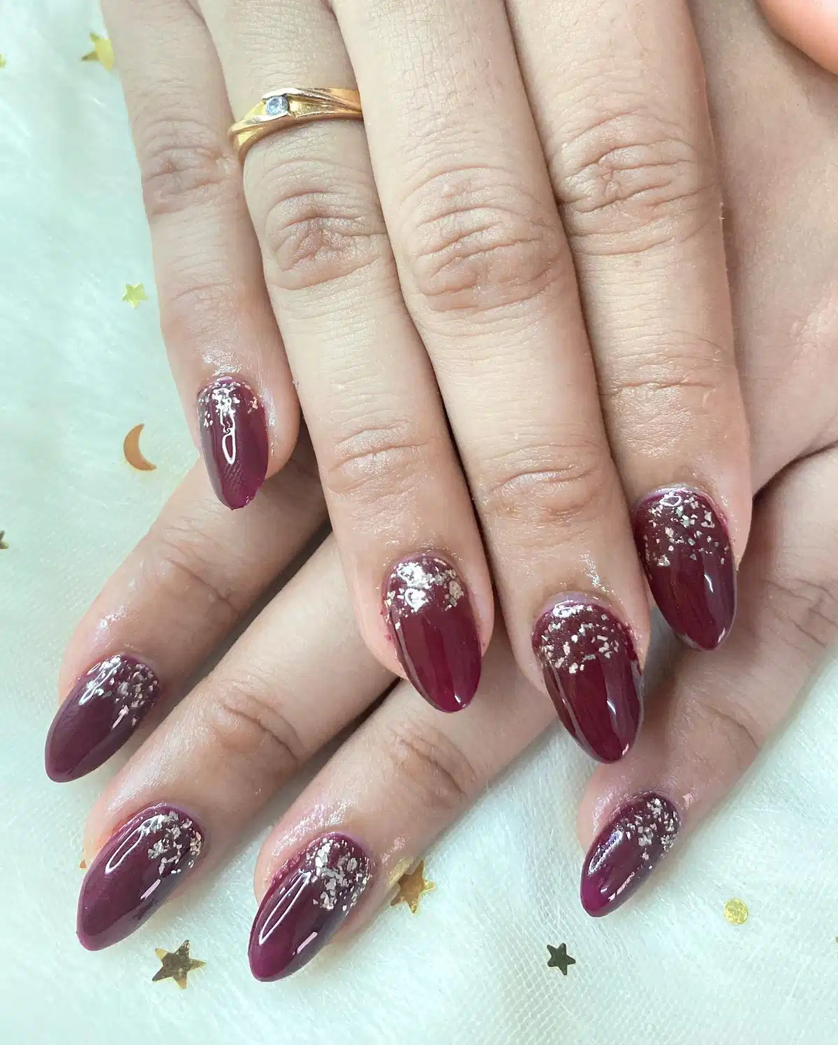 Maroon almond nails with silver flake accents