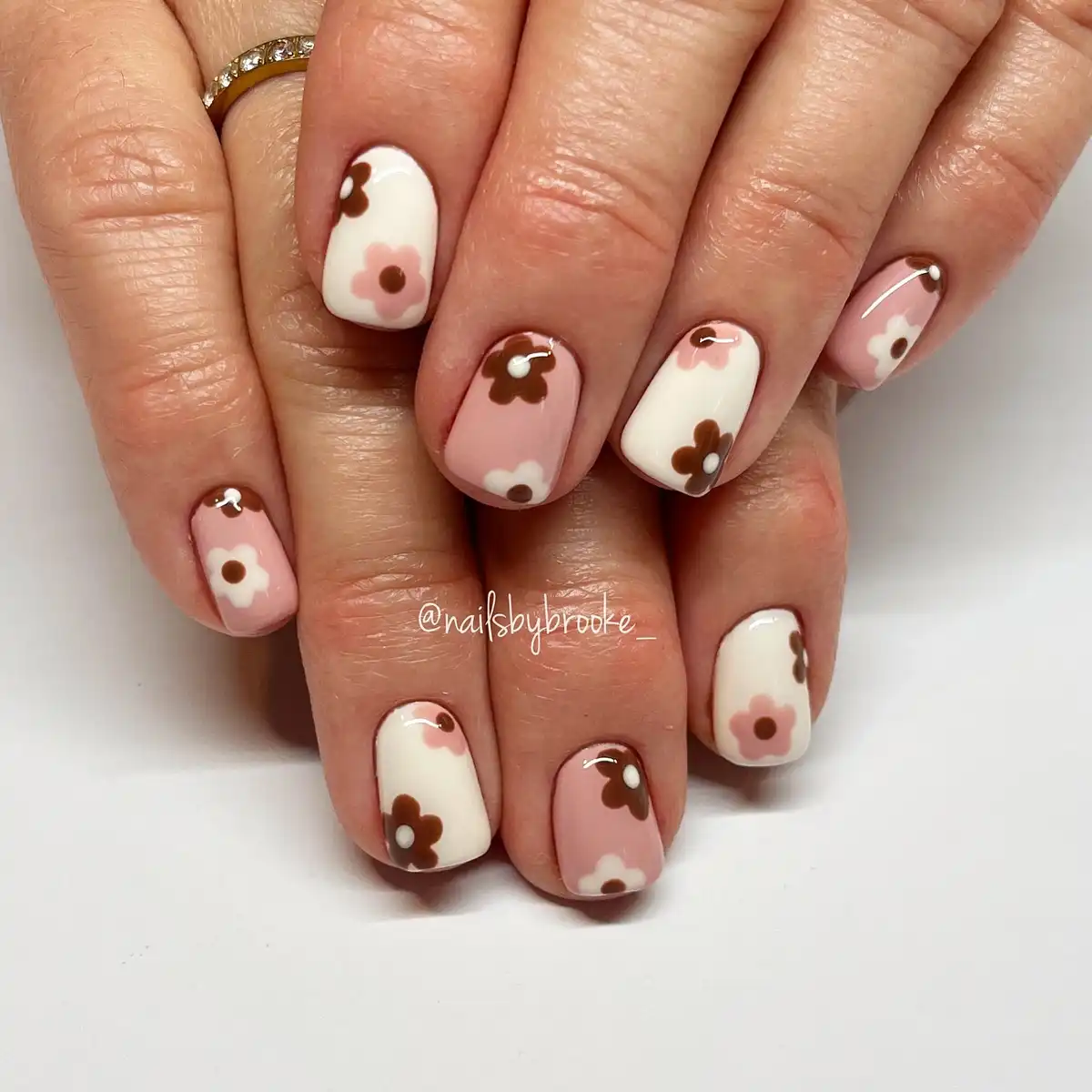 Pale pink and white nails with simple floral shapes