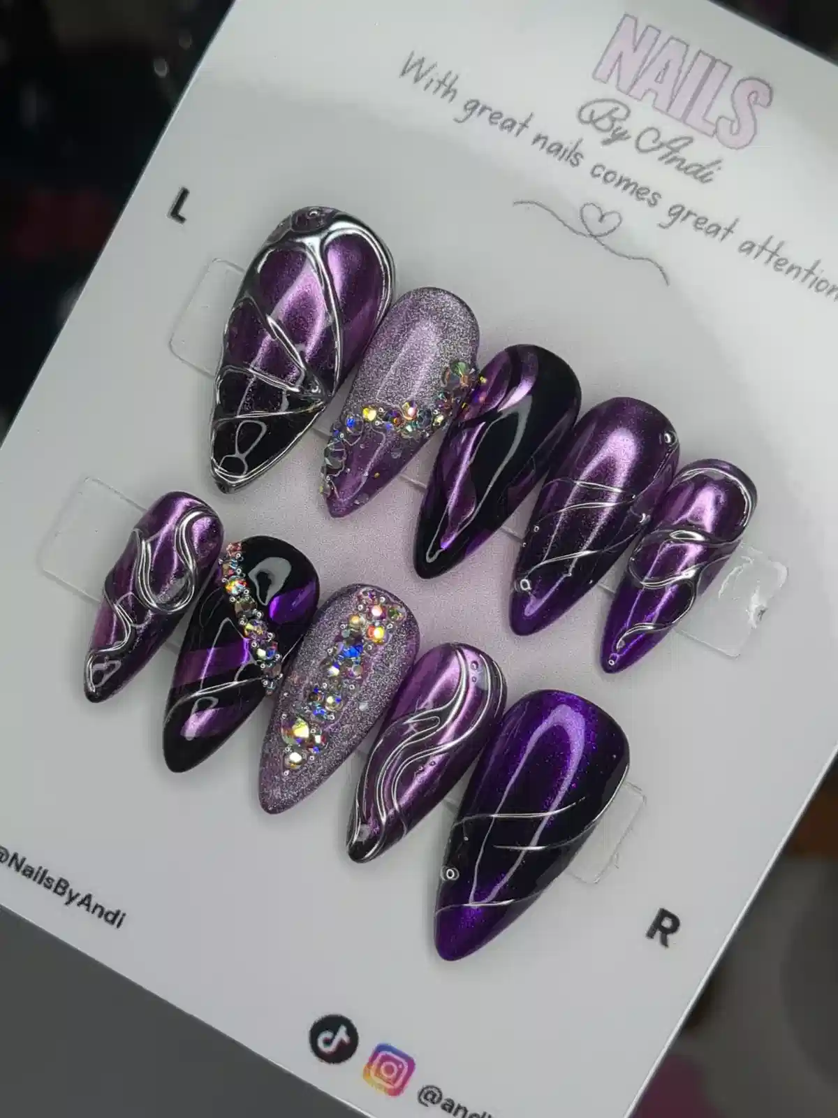 Purple-and-black metallic nail set with silver linework and rhinestone clusters