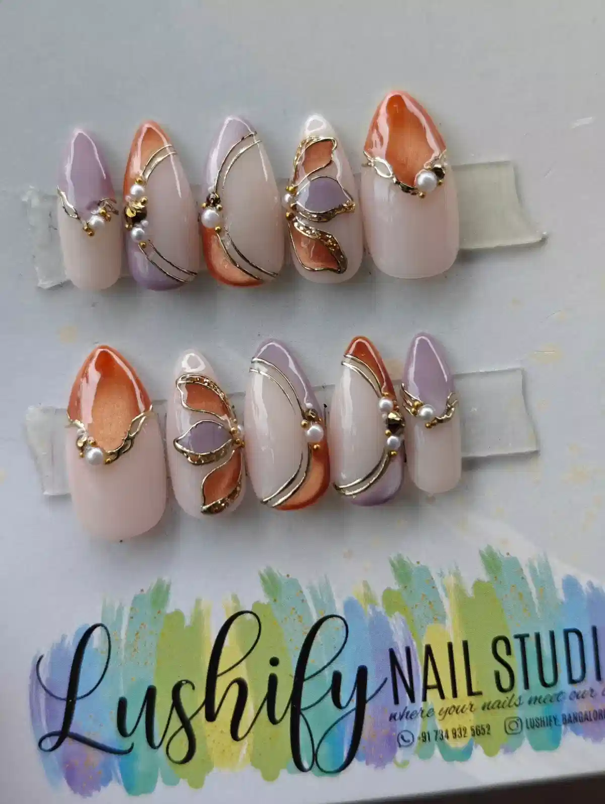 Nude set with lavender/orange accents, gold lines, and pearls