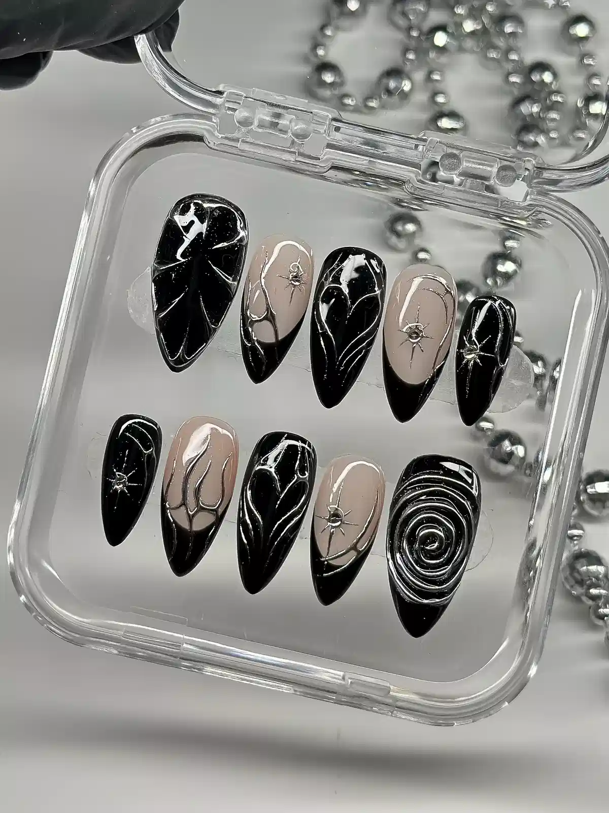 Black-and-nude pointed set with silver line art and spiral accent