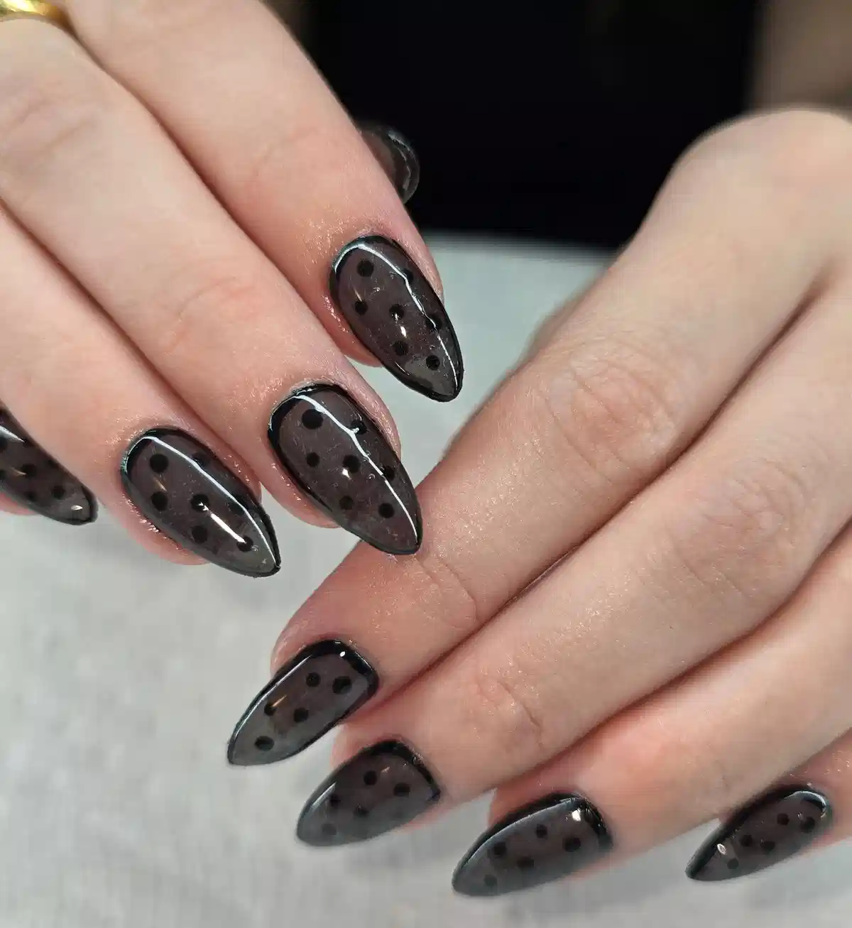 Sheer dark polka-dot pointed nails with outlined edges