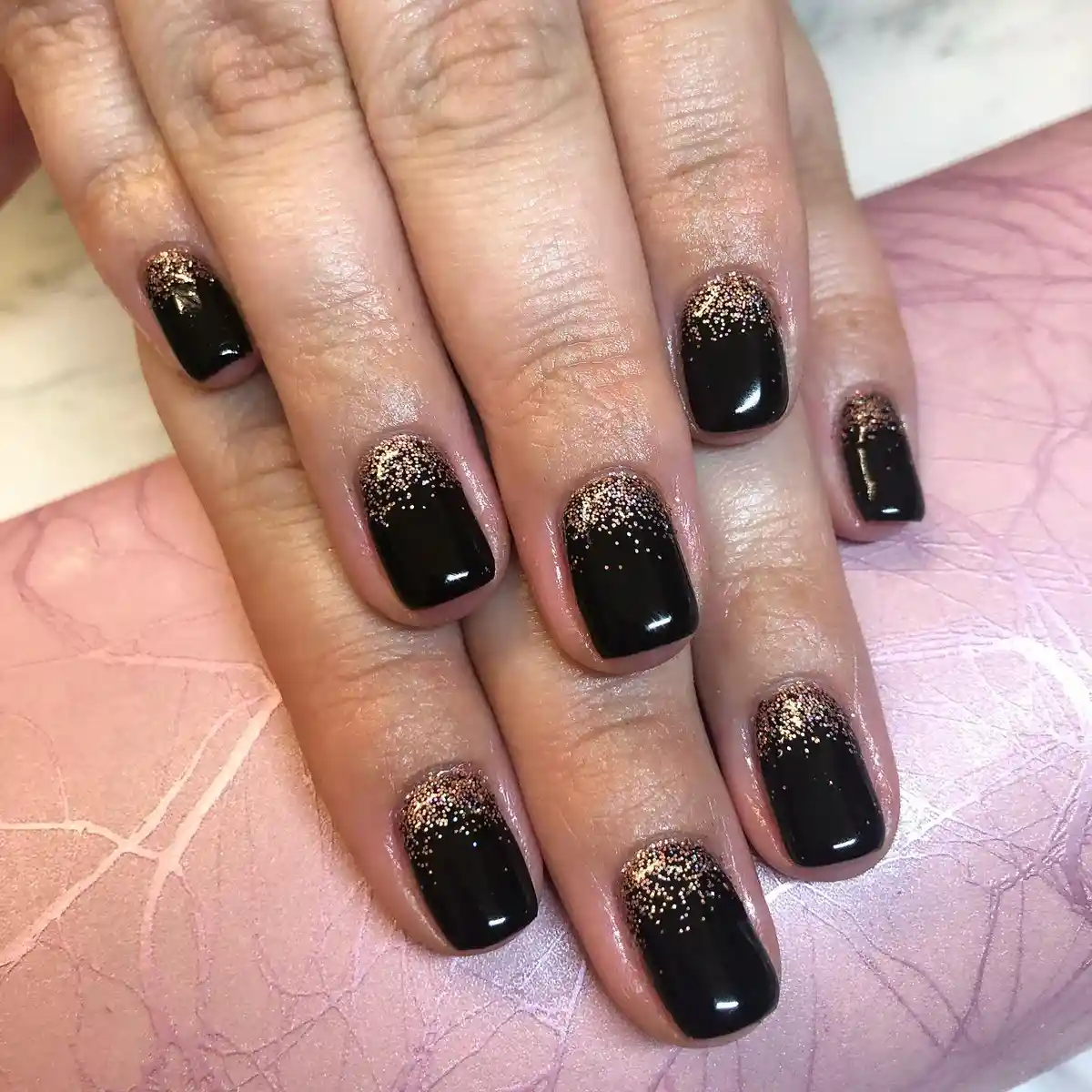 Short glossy black nails with gold glitter cuticle gradient