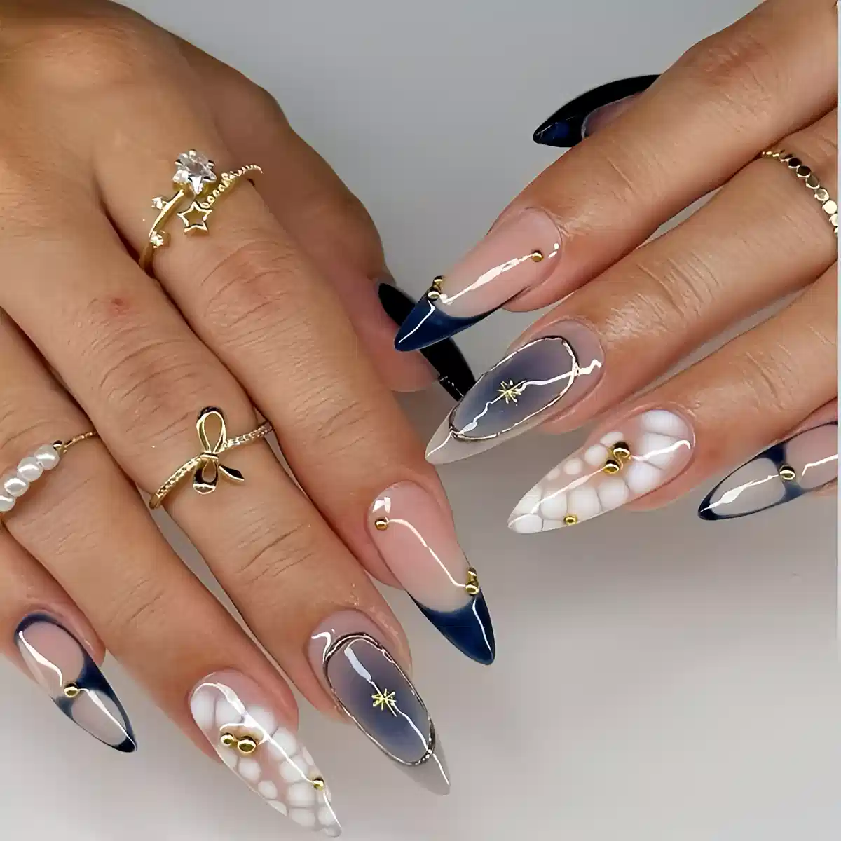Blue French tips with gold studs and starburst accents