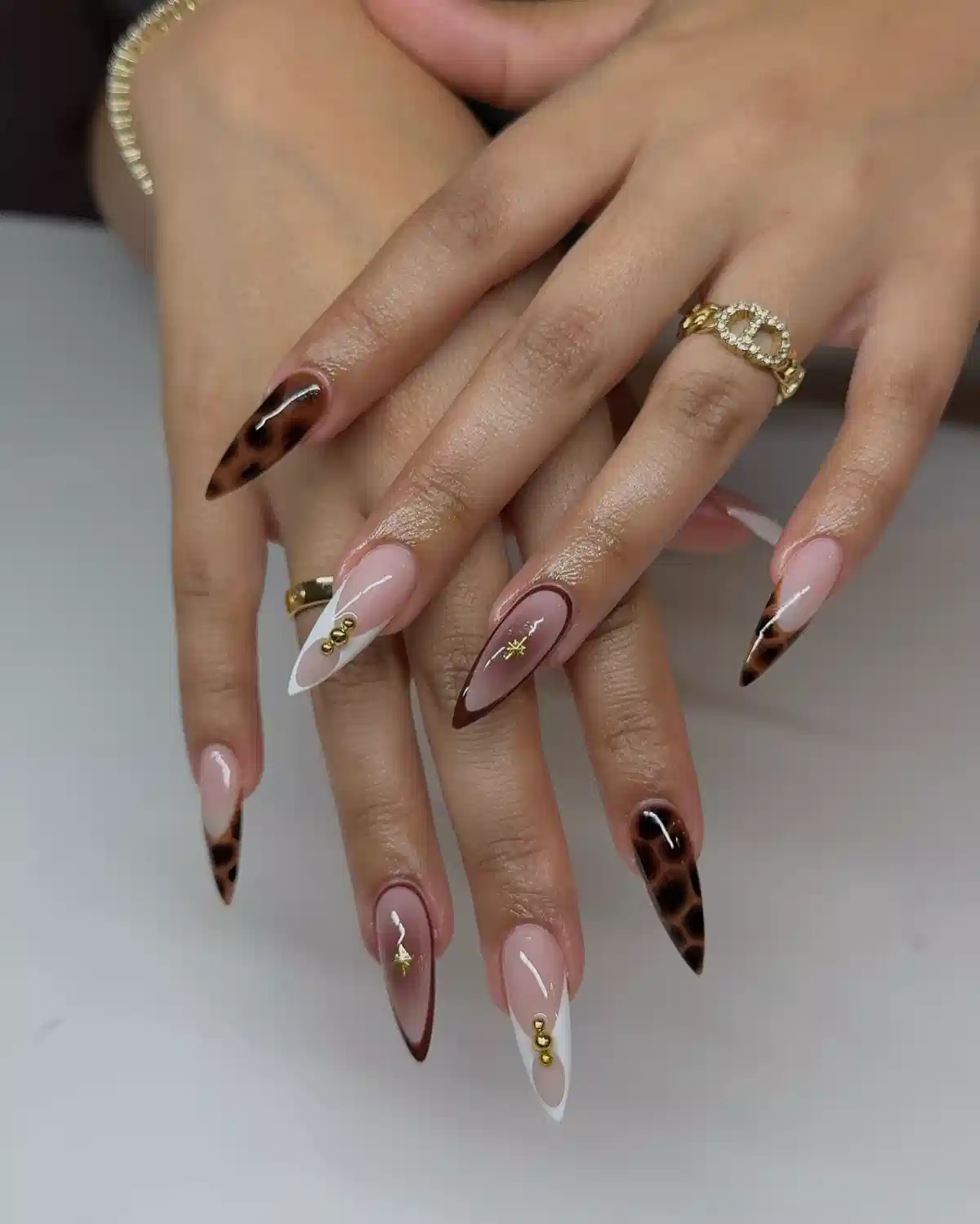 Stiletto nude set with leopard-print tips, white diagonals, and gold starbursts
