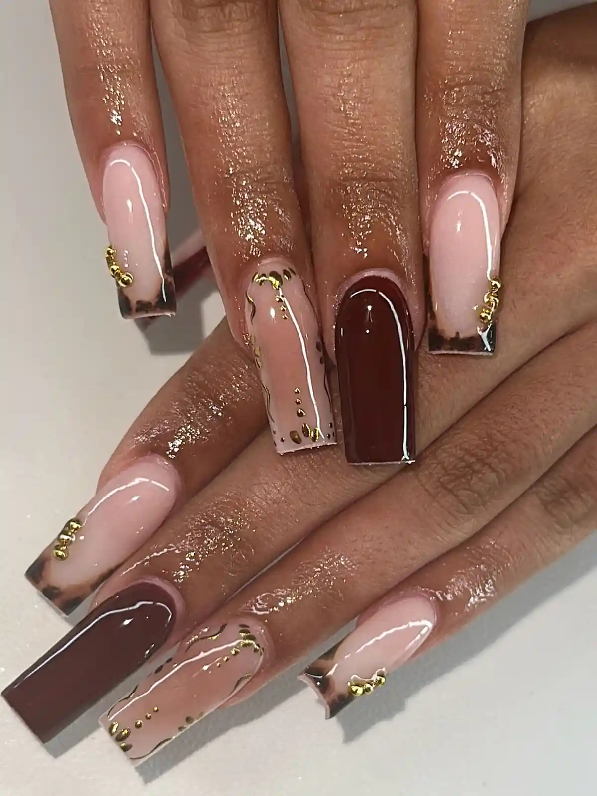 Long square nude-and-brown mix with gold studs and chain accents
