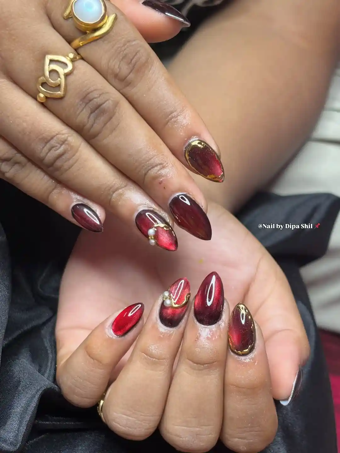 Deep red cat-eye look with gold edging and pearl accents