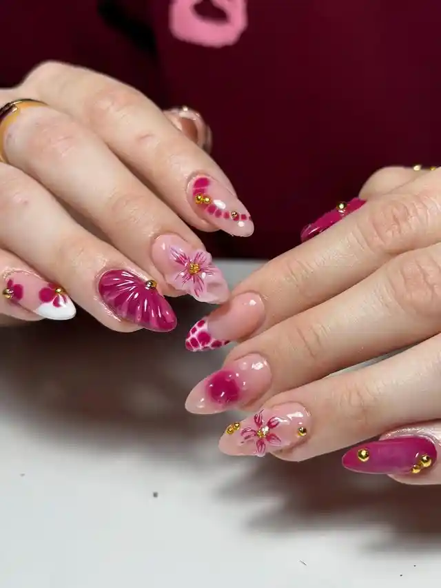 Magenta floral accents with gold studs on nude base