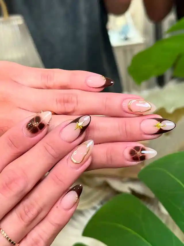 Brown French tips with gold outlines and star motifs
