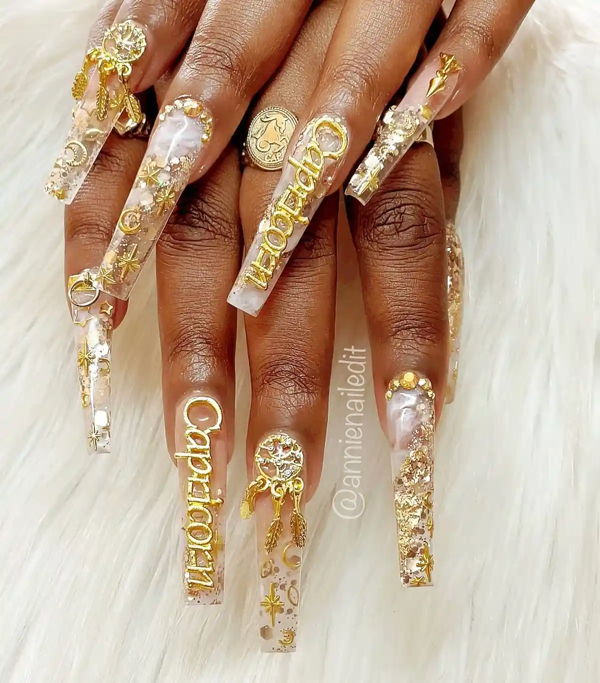 Extra-long clear nails with gold letters and celestial motifs