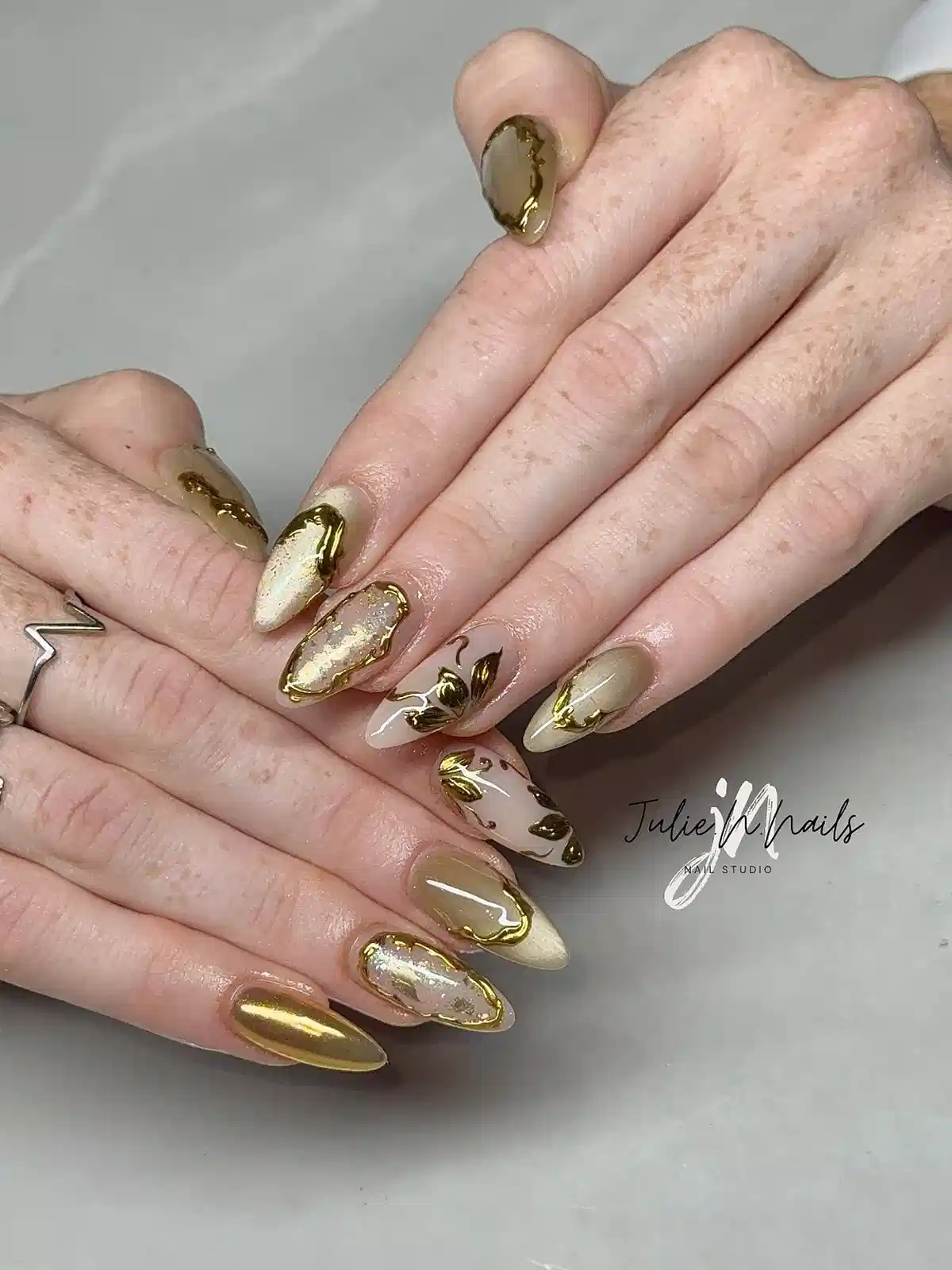 Mixed metallic gold and nude nails with gold edging and foil accents