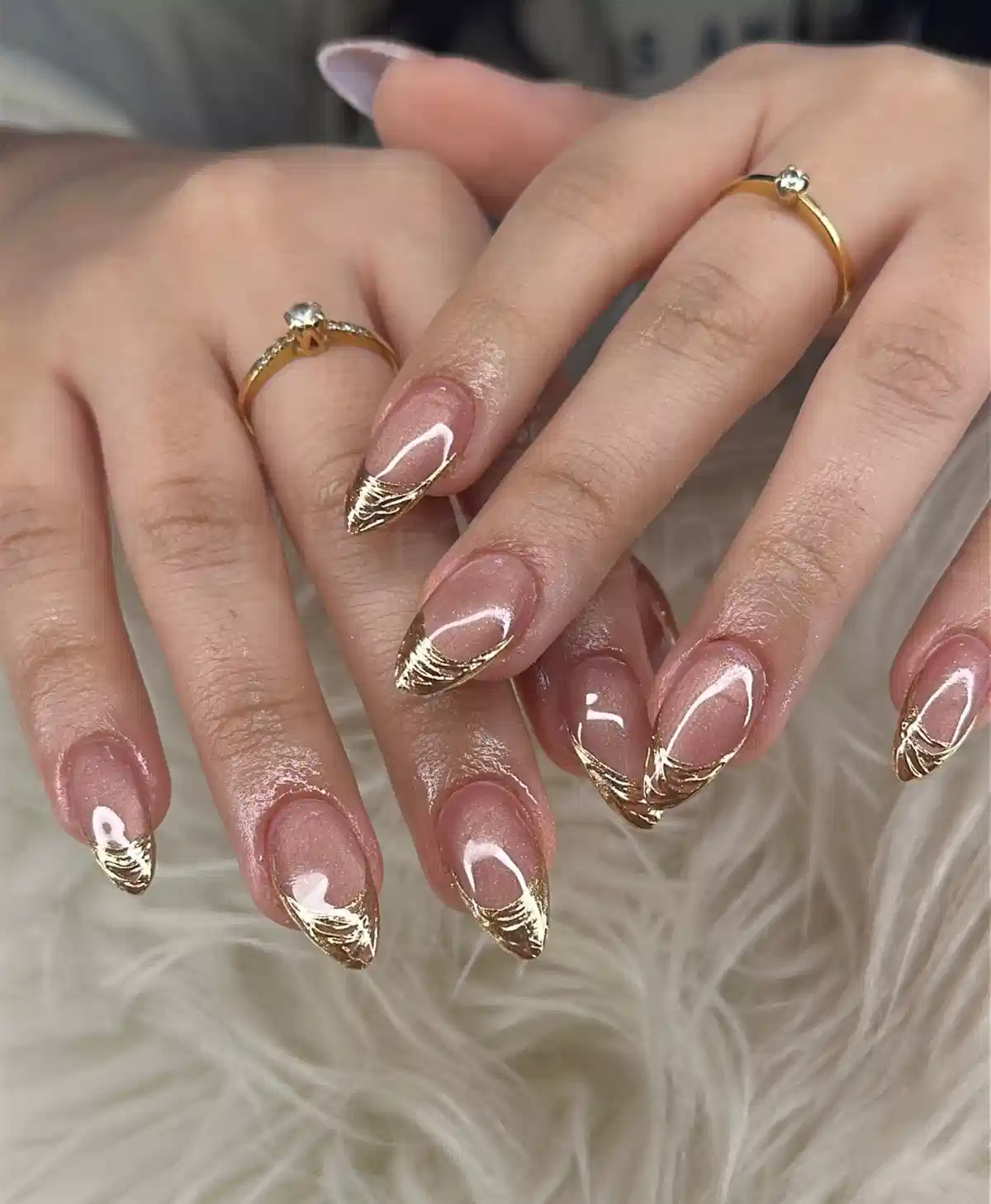 Gold striped French-tip effect on almond nails