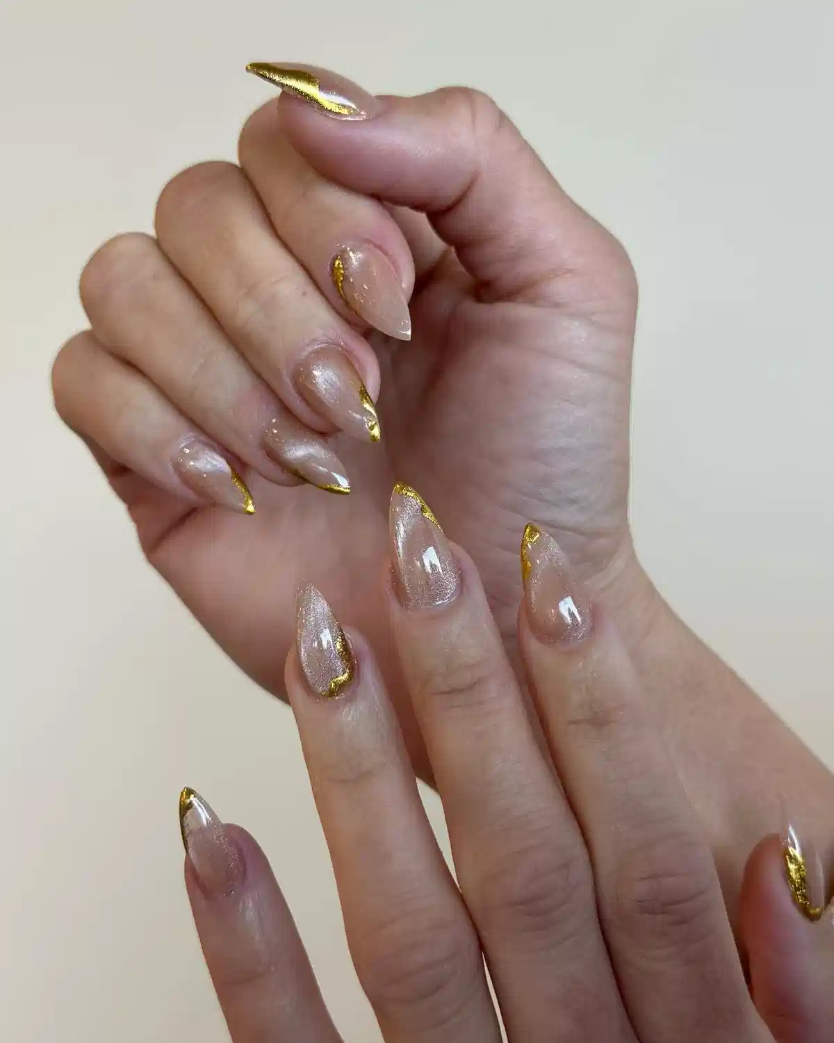 Sheer shimmery nude nails with irregular gold accents