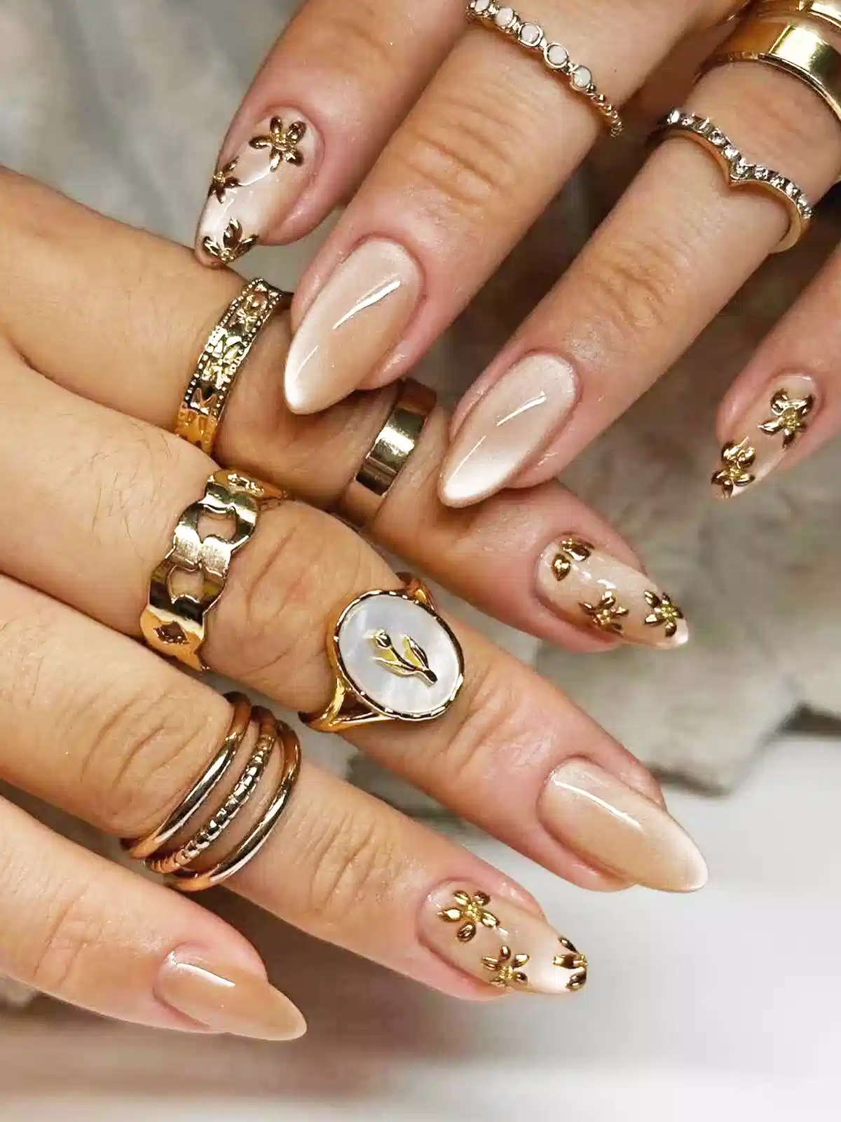 Nude almond nails with gold flower accents