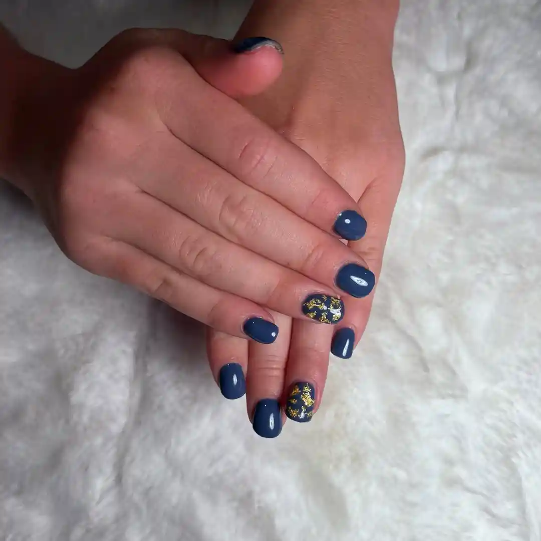 Glossy navy nails with gold-flake accent nails