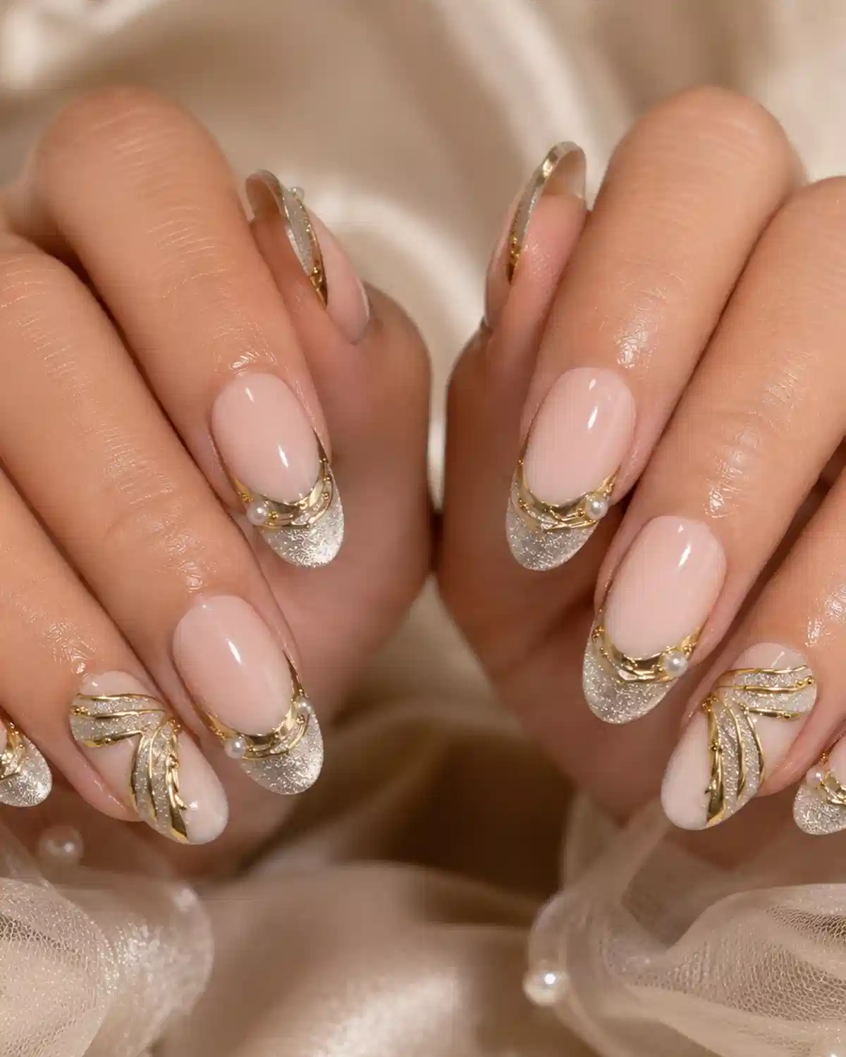 Silver-glitter French tips with gold curves and pearl accents