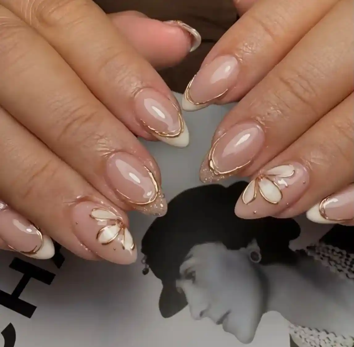 Gold-outlined French tips with floral line art