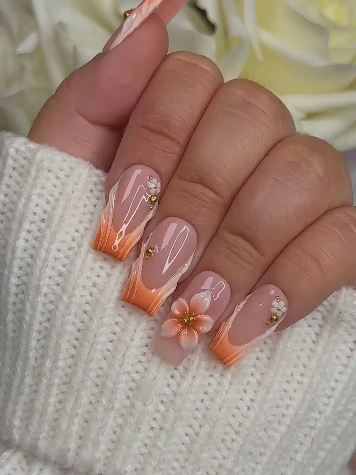 Orange ombré French tips with floral and gold accents