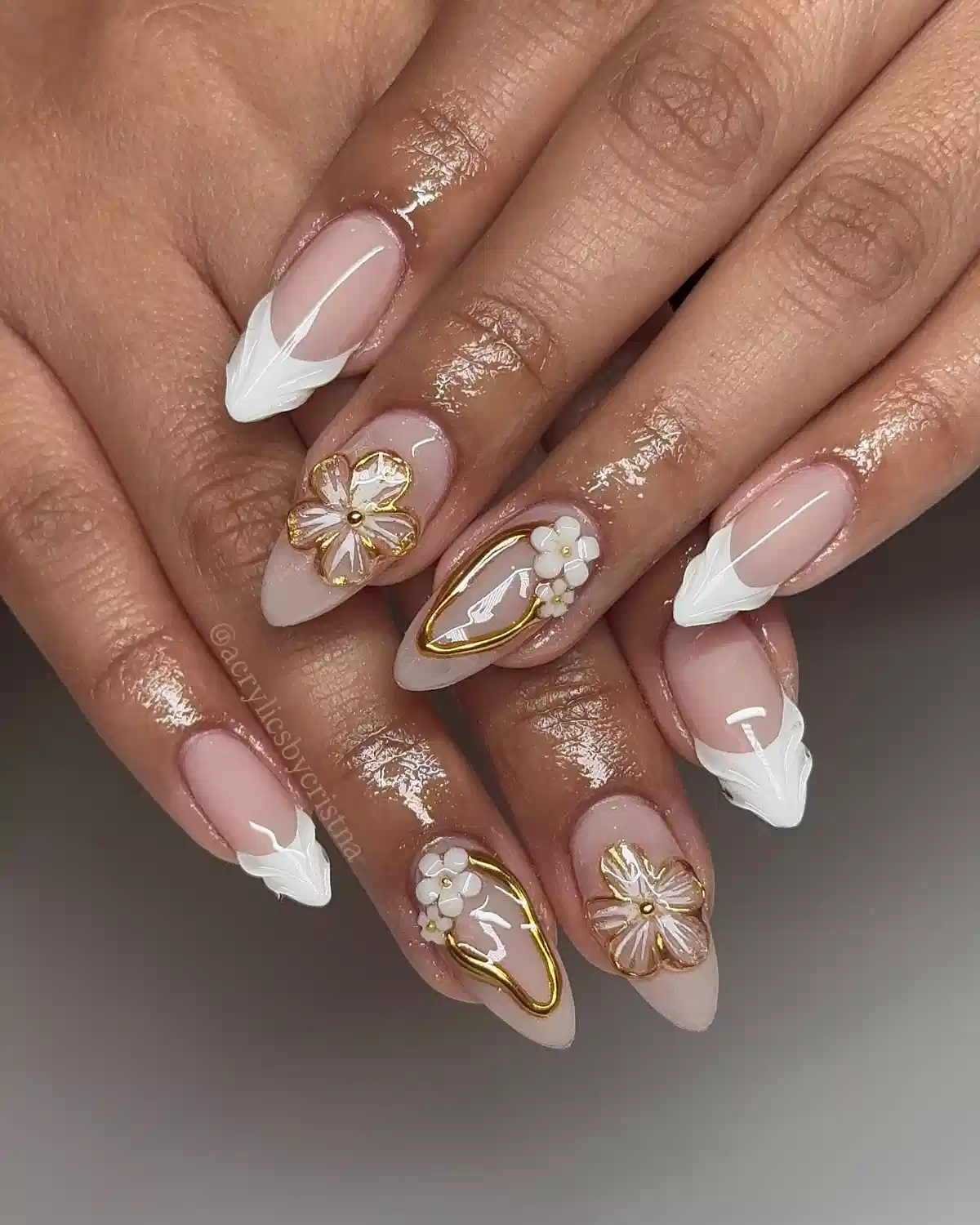 Nude base with sculpted white tips and gold-framed floral accents