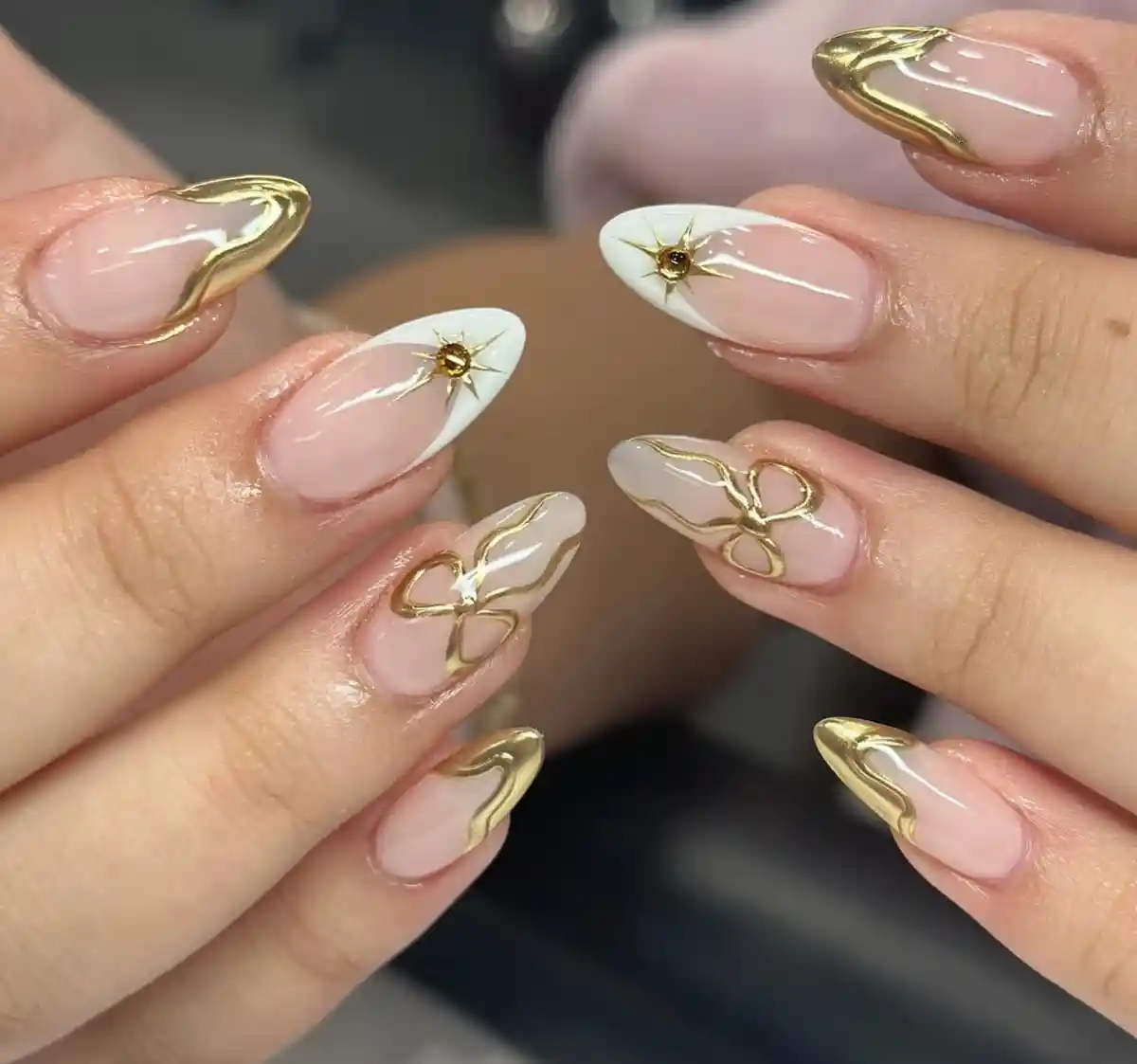 Gold-edged nude set with white tips, starbursts, and bow line art