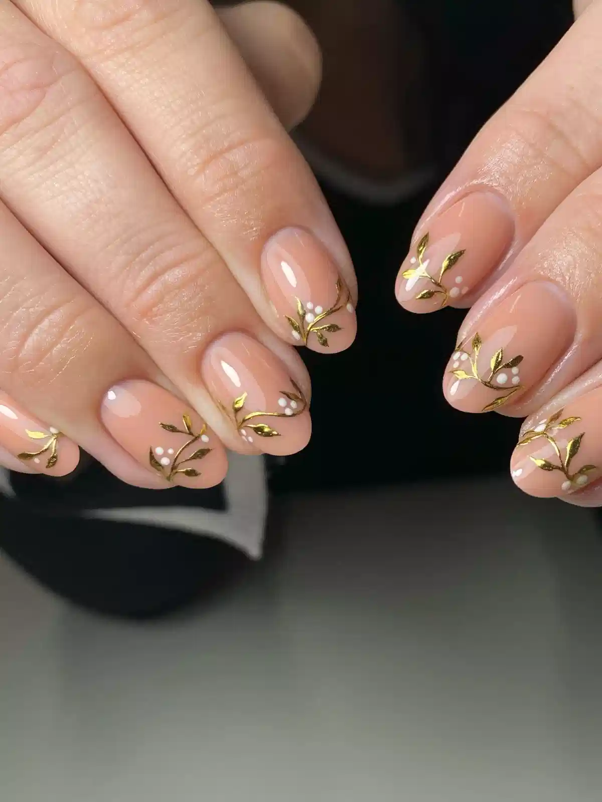 Nude short nails with gold botanical branches and white dot clusters