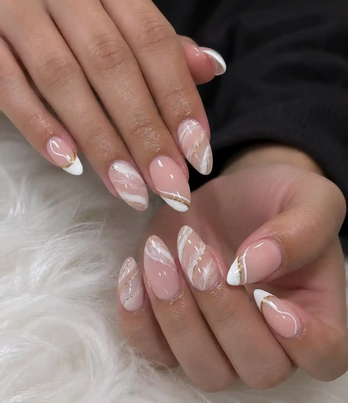 Nude almond nails with white swirls and thin gold lines