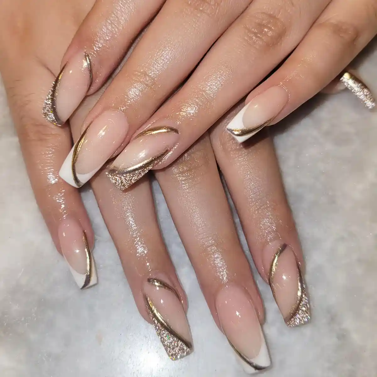 Nude coffin nails with white diagonal tips and gold swoops