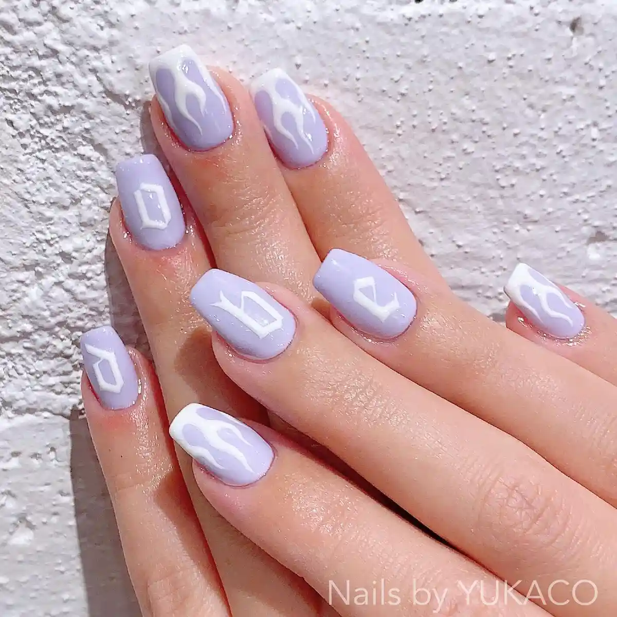 Pastel lavender squares with white flames and letter-like symbols