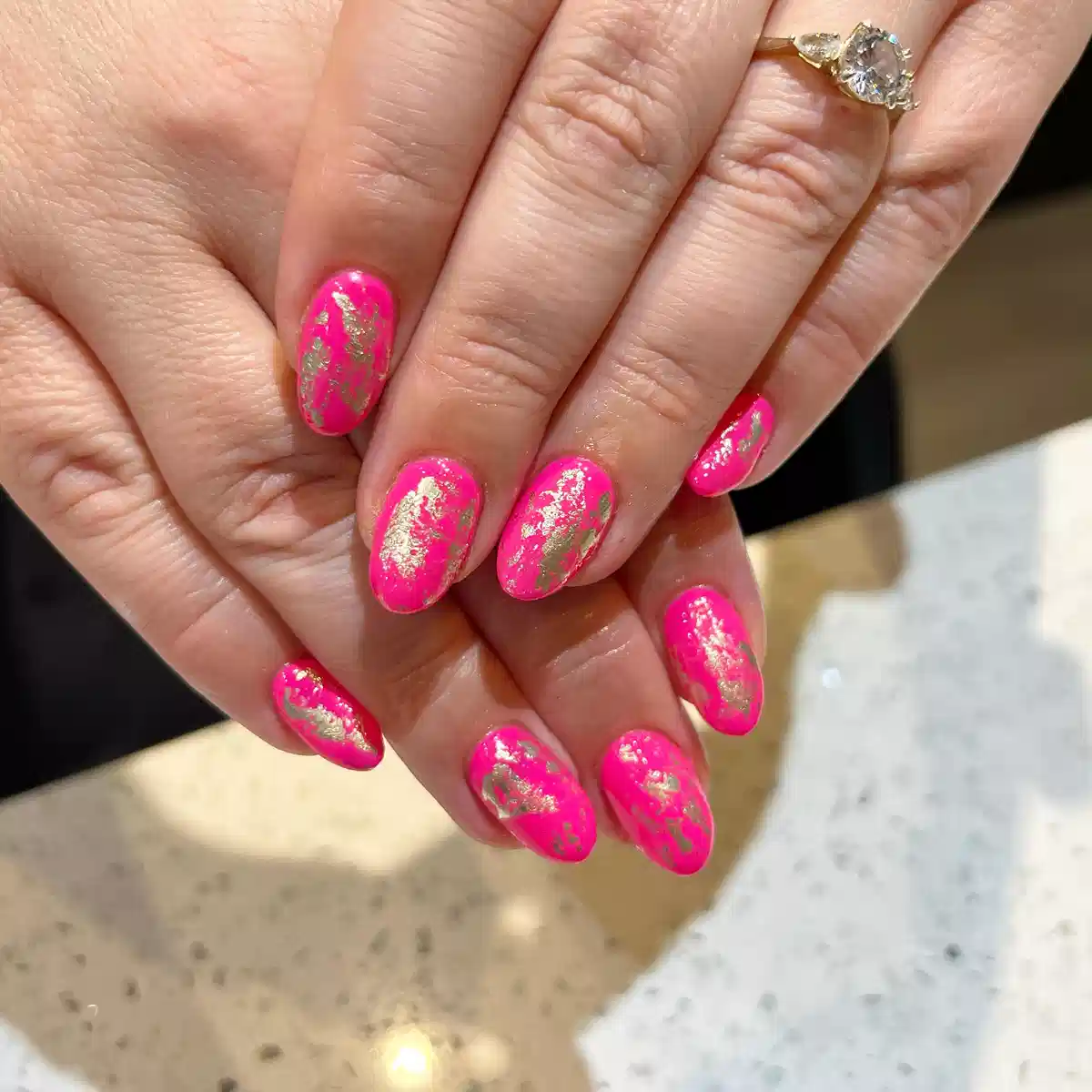 Hot pink nails with scattered gold foil effect