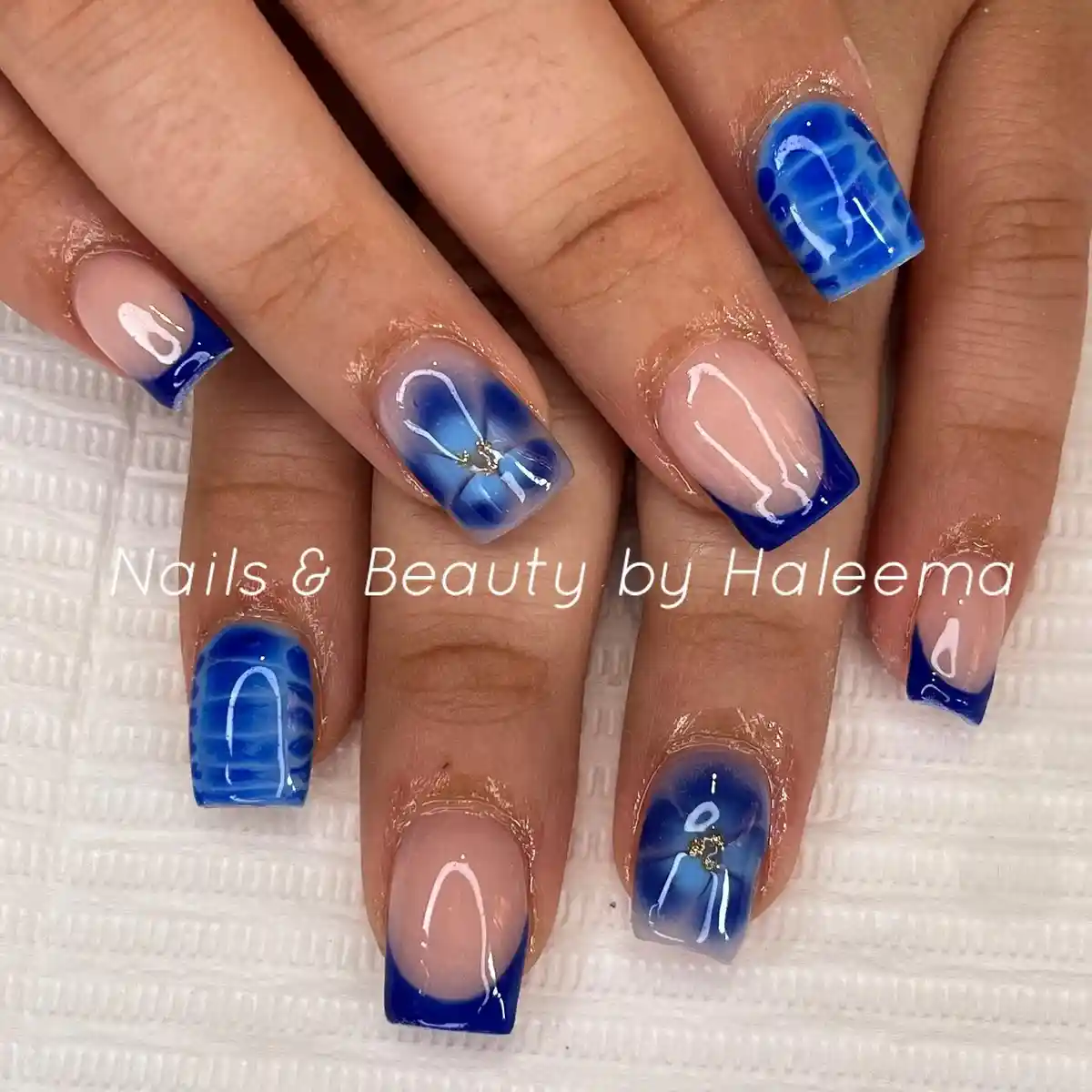 Blue French tips with marbled accents on square nails