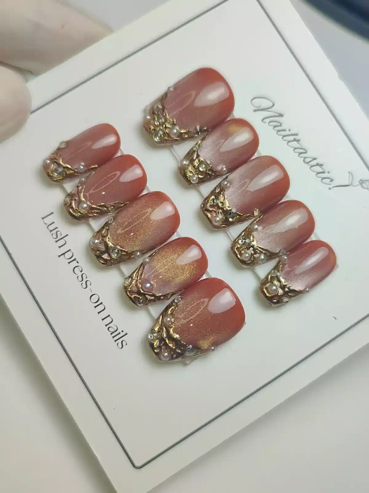 Boxed brown press-on set with ornate gold corner embellishments
