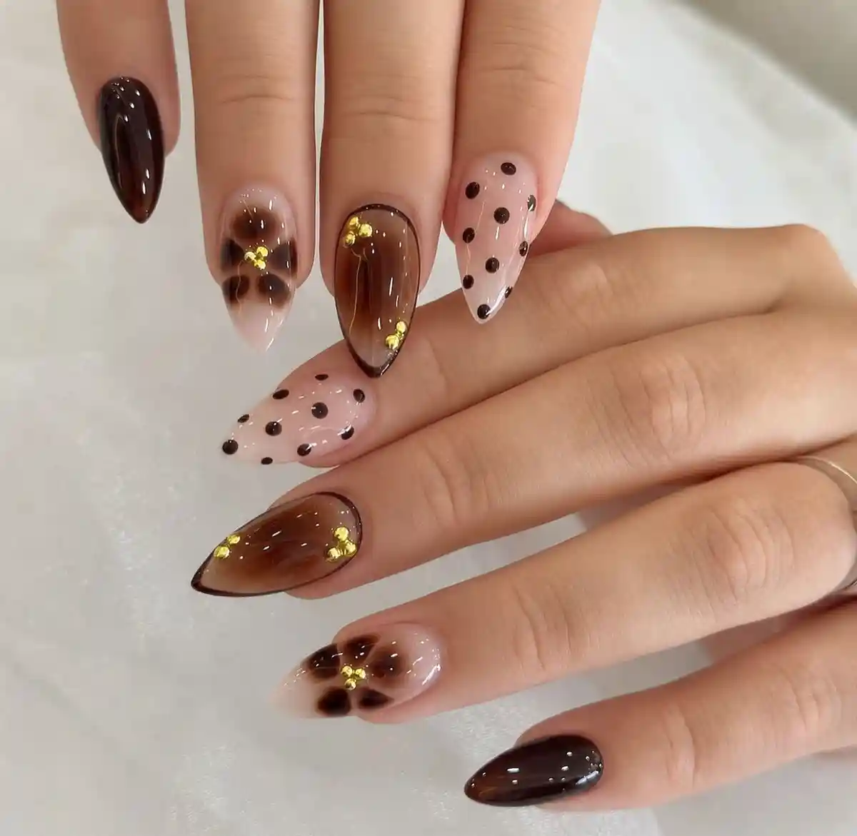 Stiletto set with dark brown solids, polka dots, and floral-like brown accents