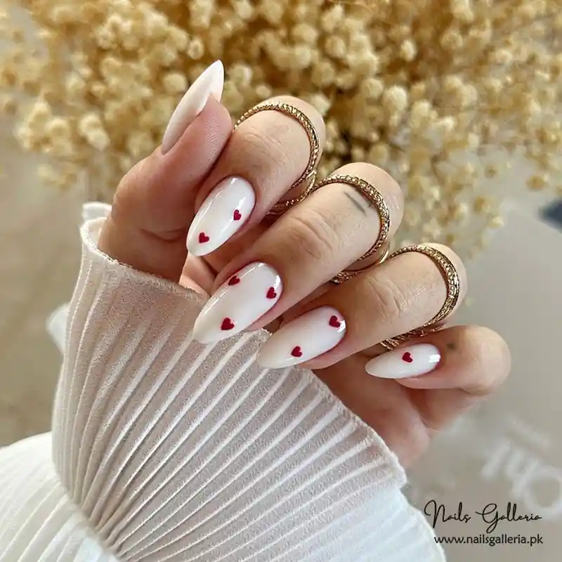 Glossy white nails with small red hearts