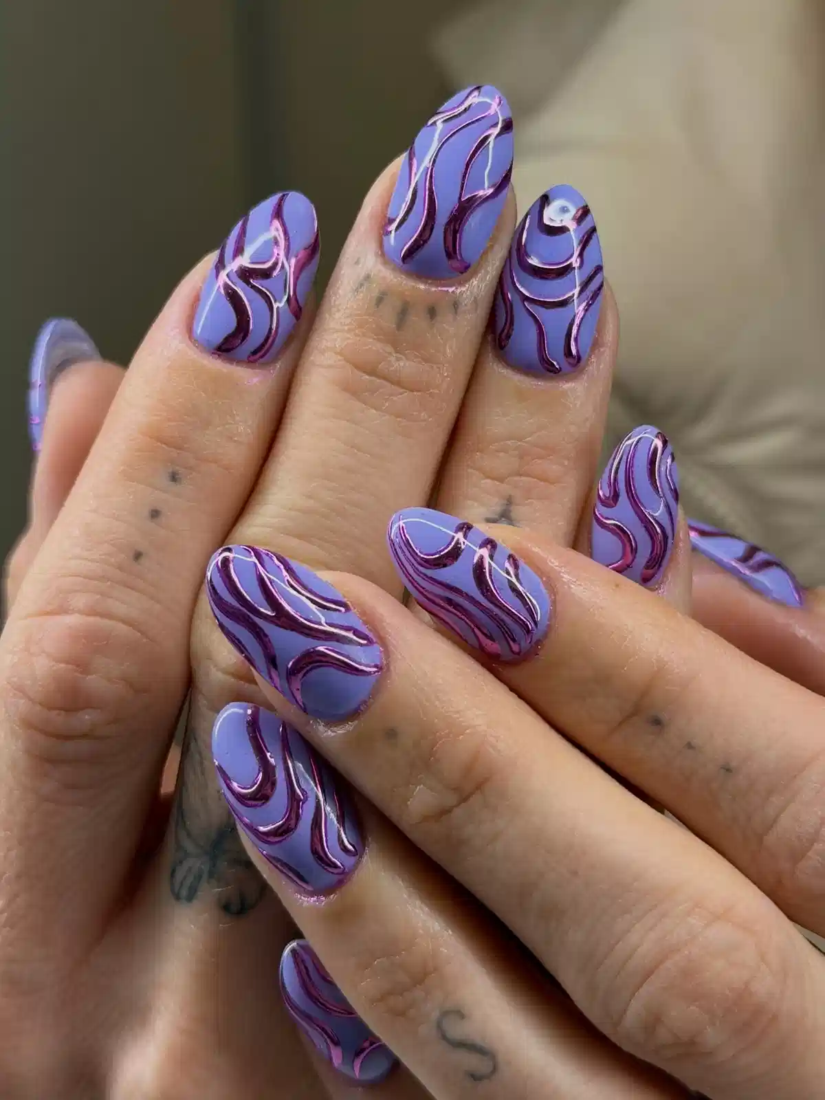 Periwinkle nails with raised wavy dark-purple and metallic-pink lines