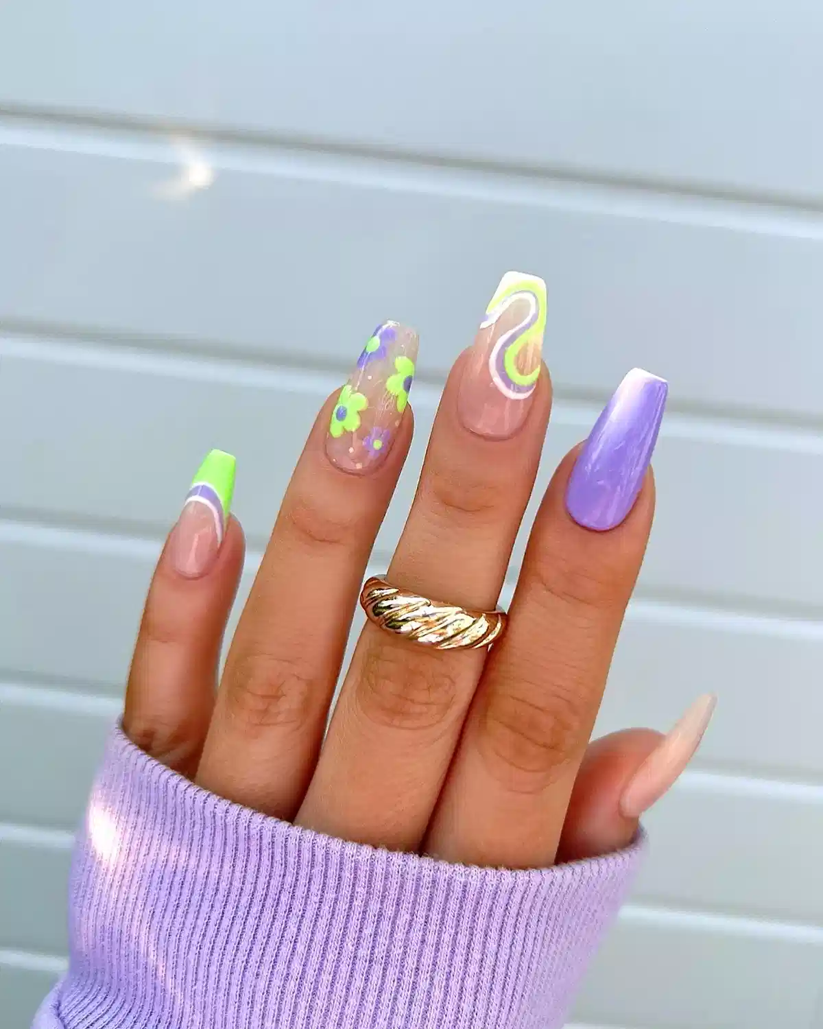 Lavender coffin nails with neon green tips and floral accents