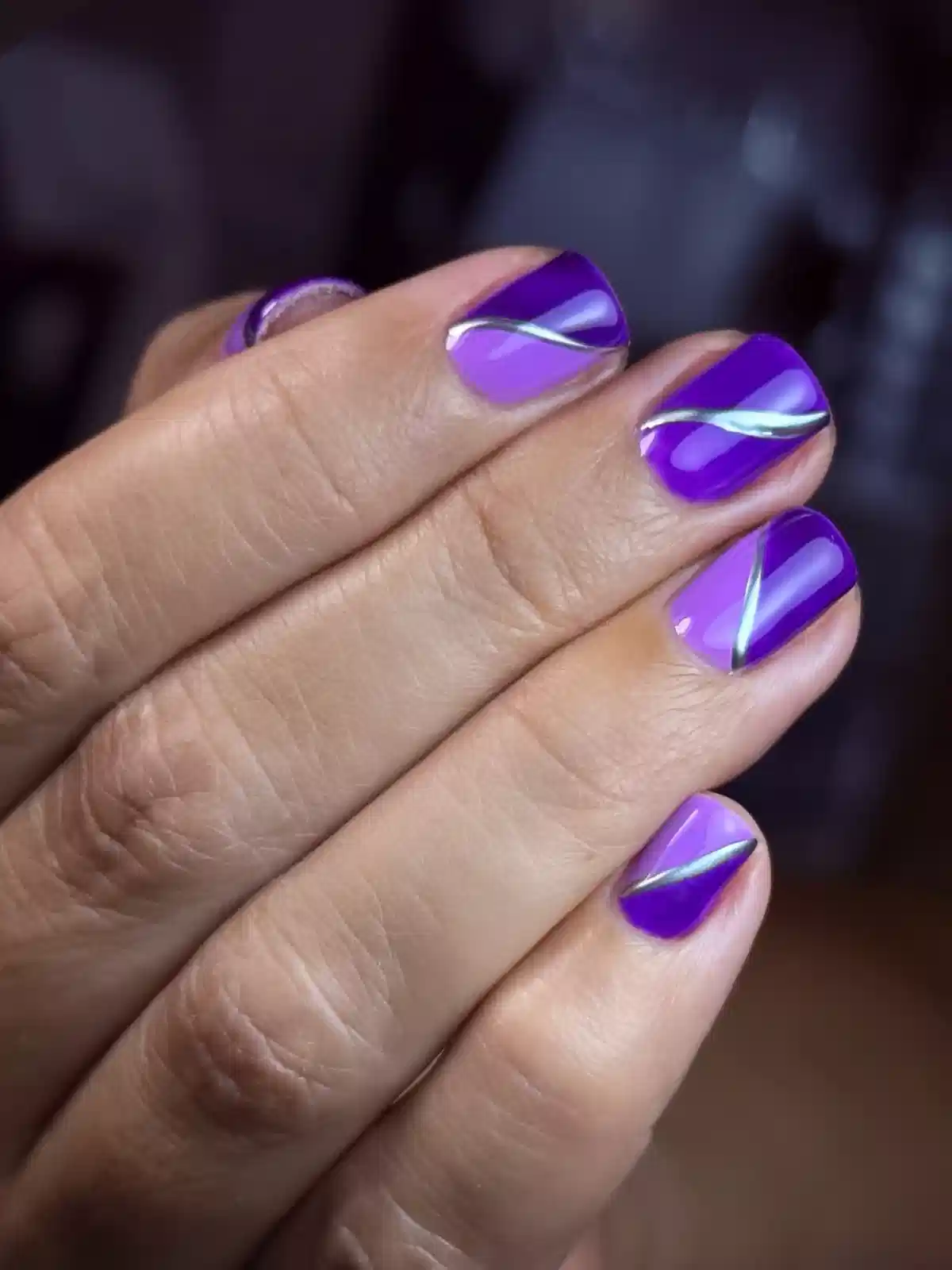 Two-tone purple nails with diagonal silver stripes