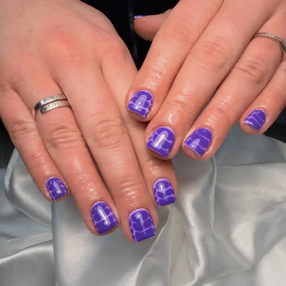 Short purple nails with web-like line pattern
