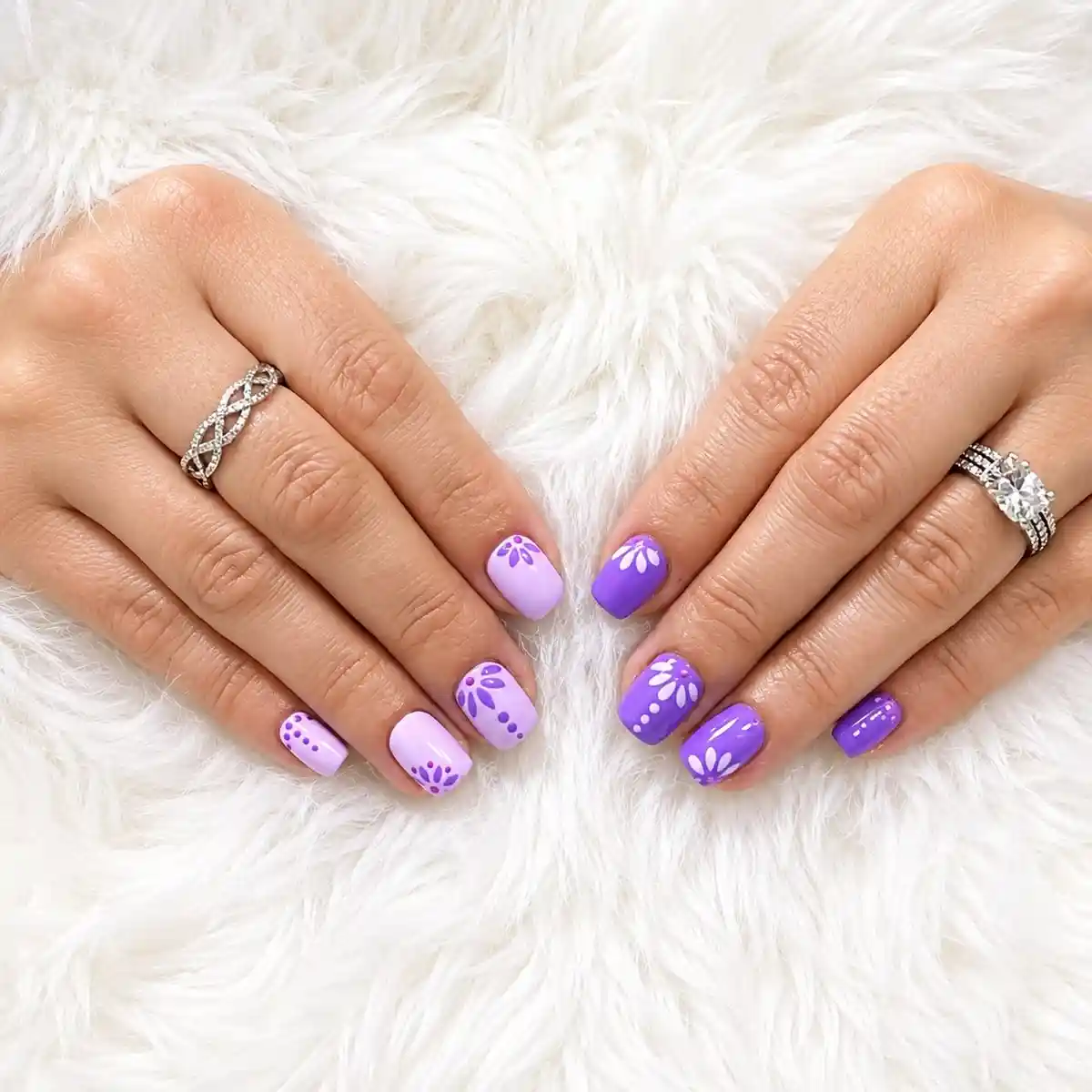 Short lavender-and-purple nails with white petal motifs
