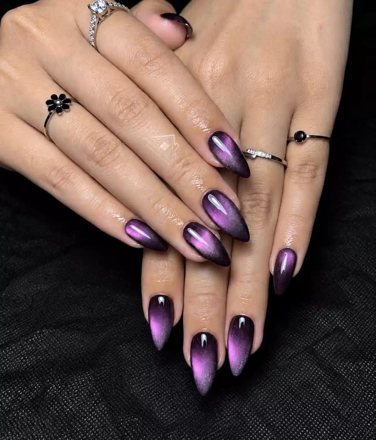 Glossy purple cat-eye almond nails with dark edges