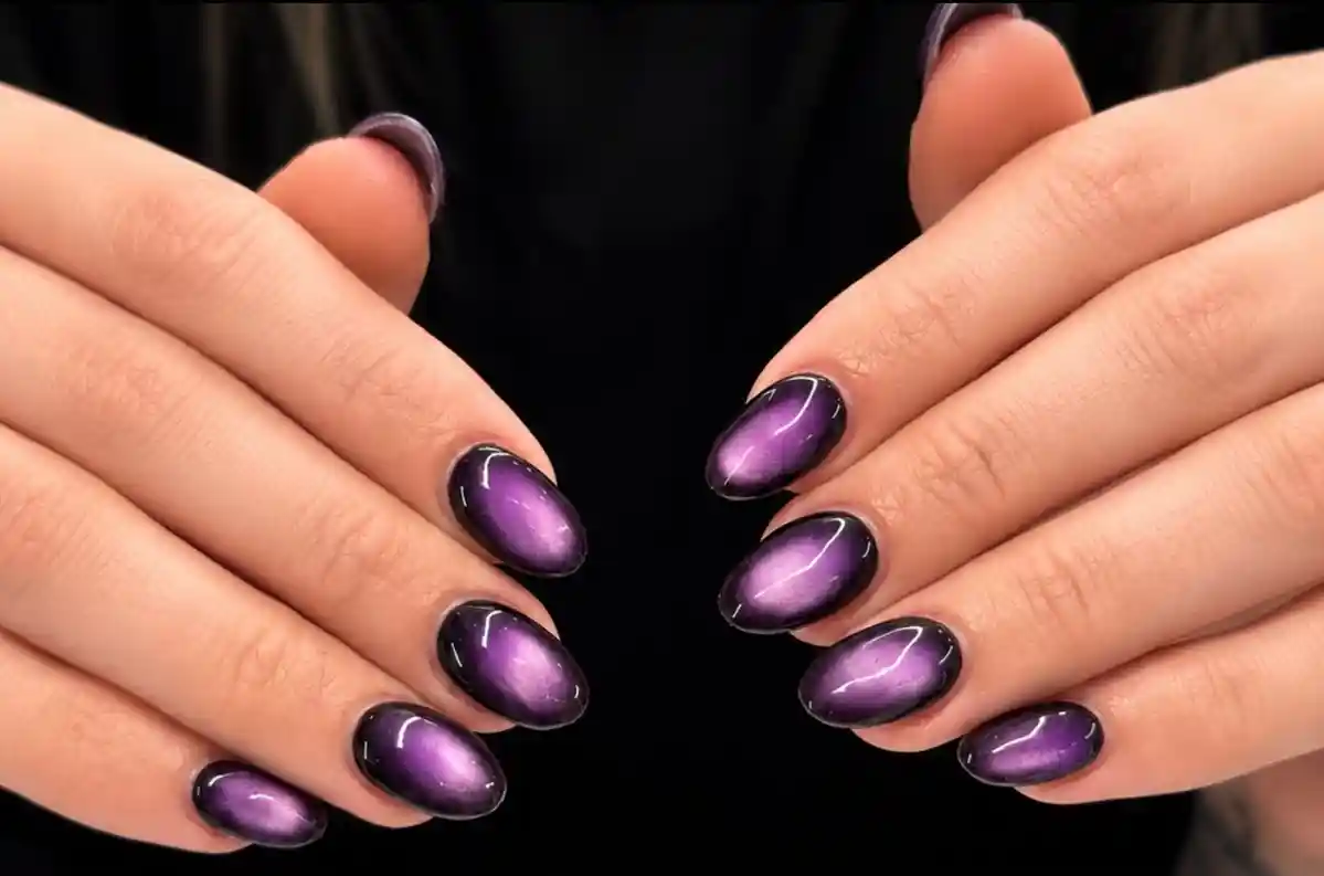 Short oval purple cat-eye nails with dark framing edges