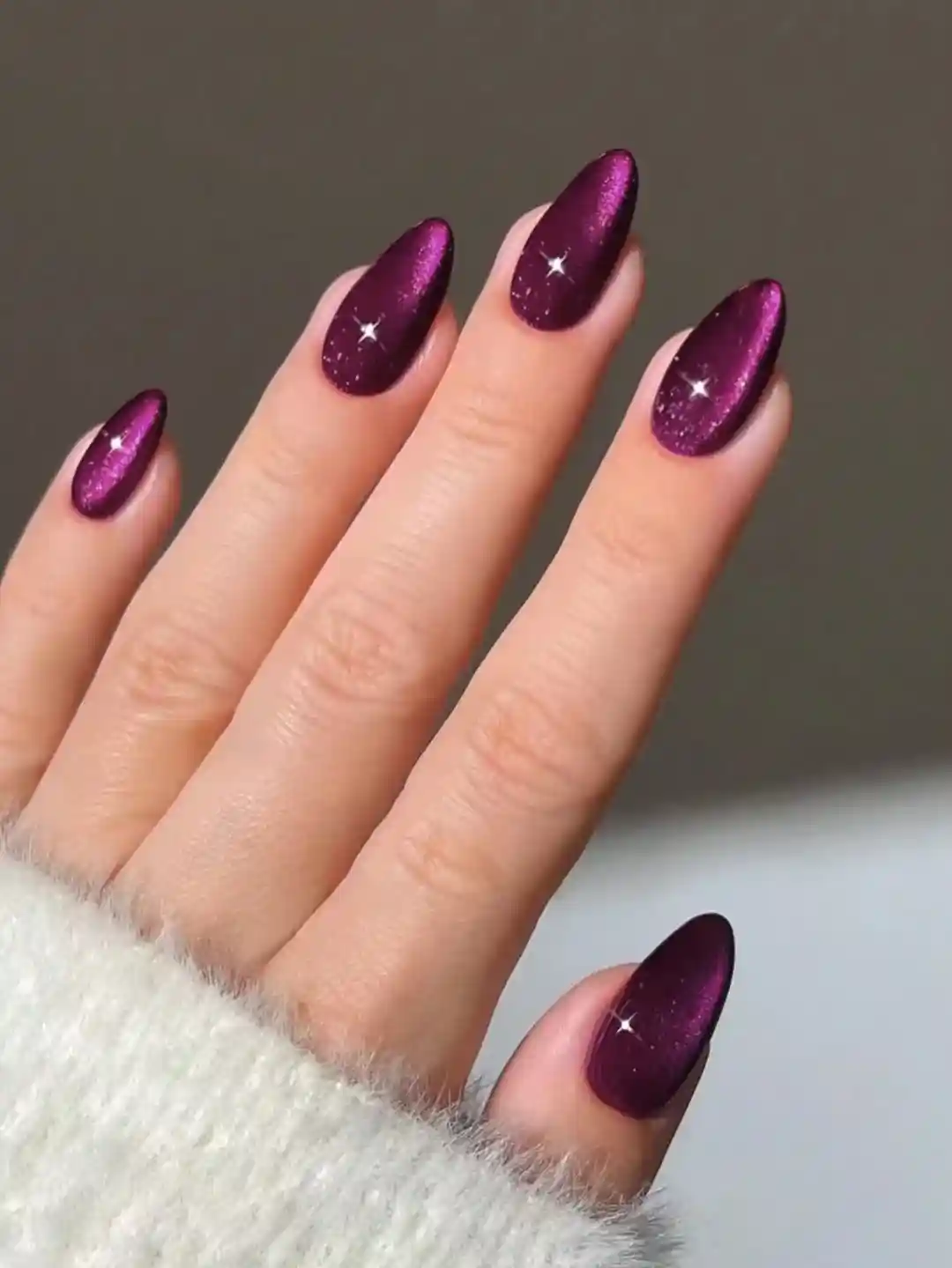Berry-purple shimmer nails with tiny star sparkle accents
