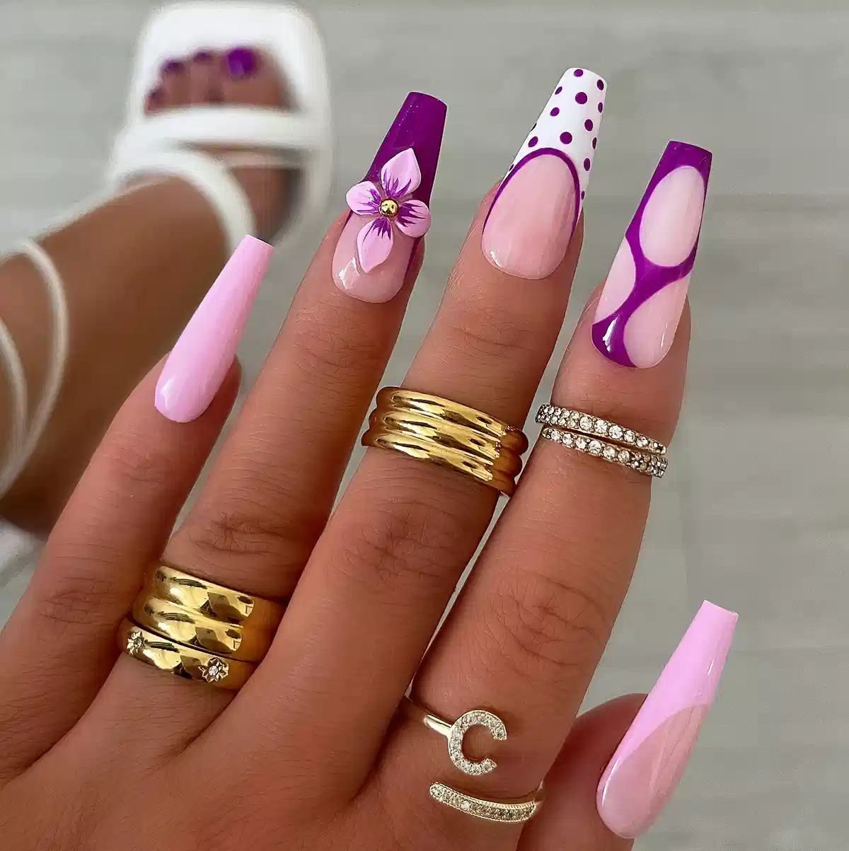Coffin nails with purple tips, polka dots, and a raised flower accent