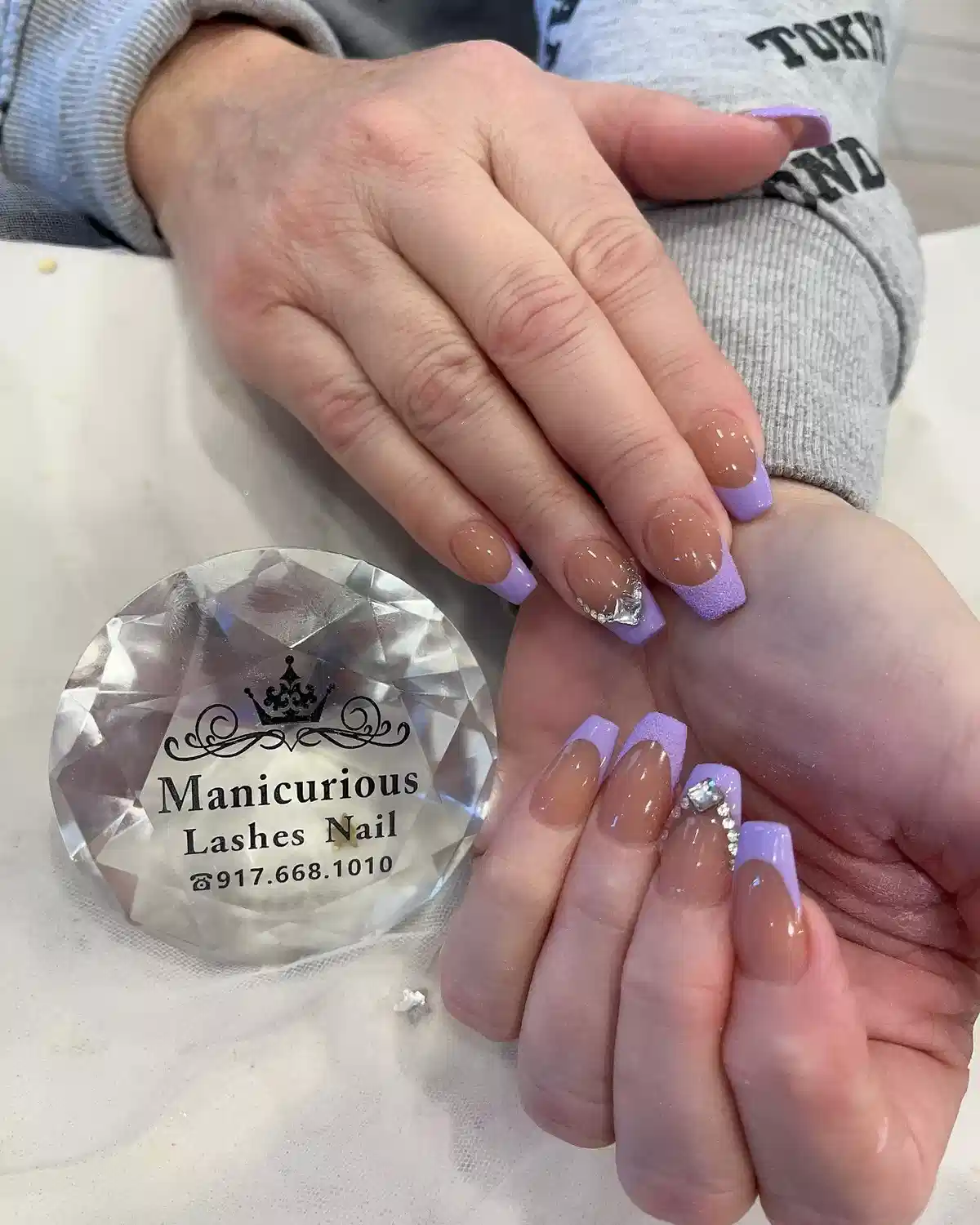 Light lavender French tips with rhinestone accent
